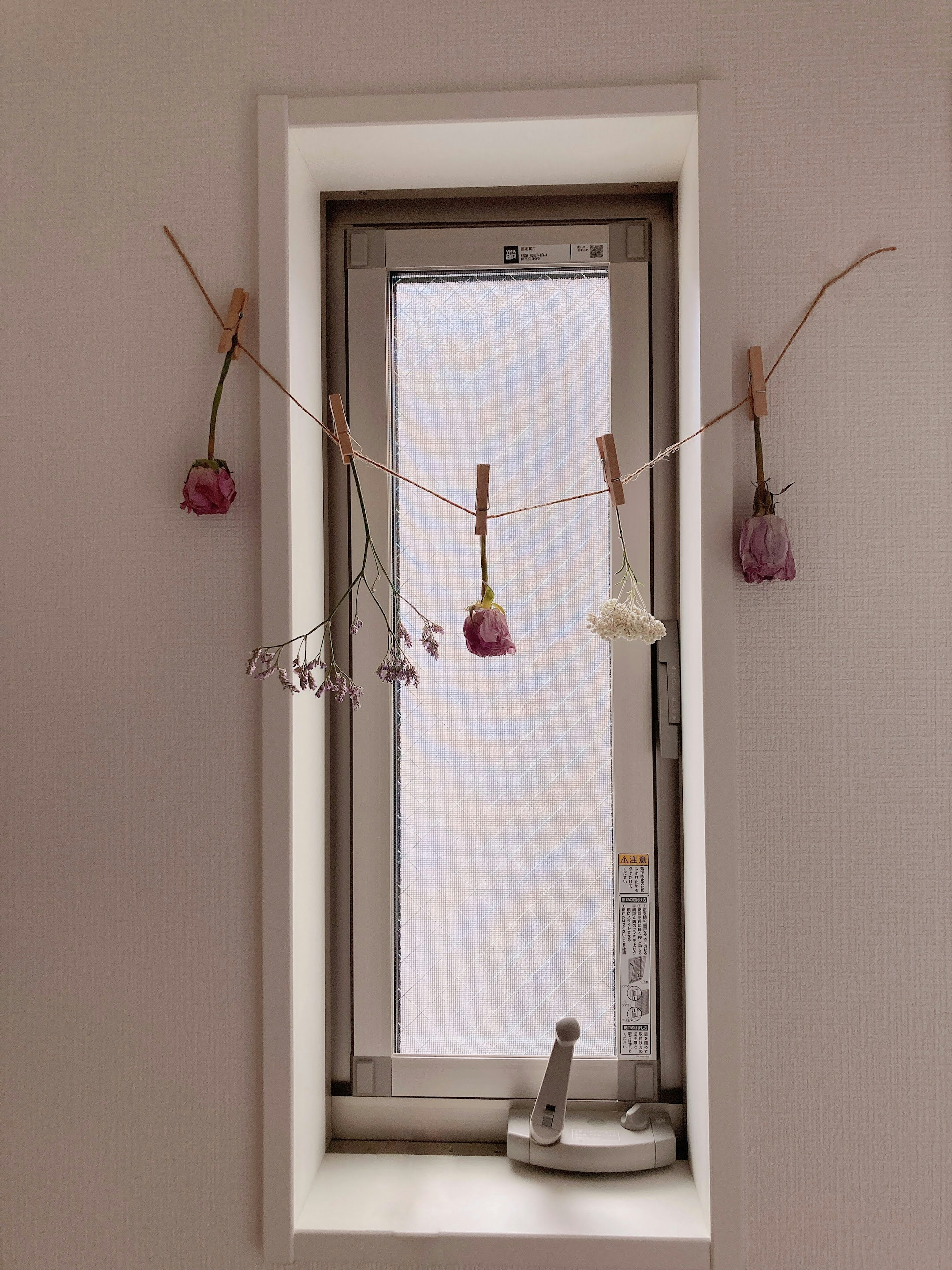 Interno con fiori e decorazioni appesi vicino a una finestra