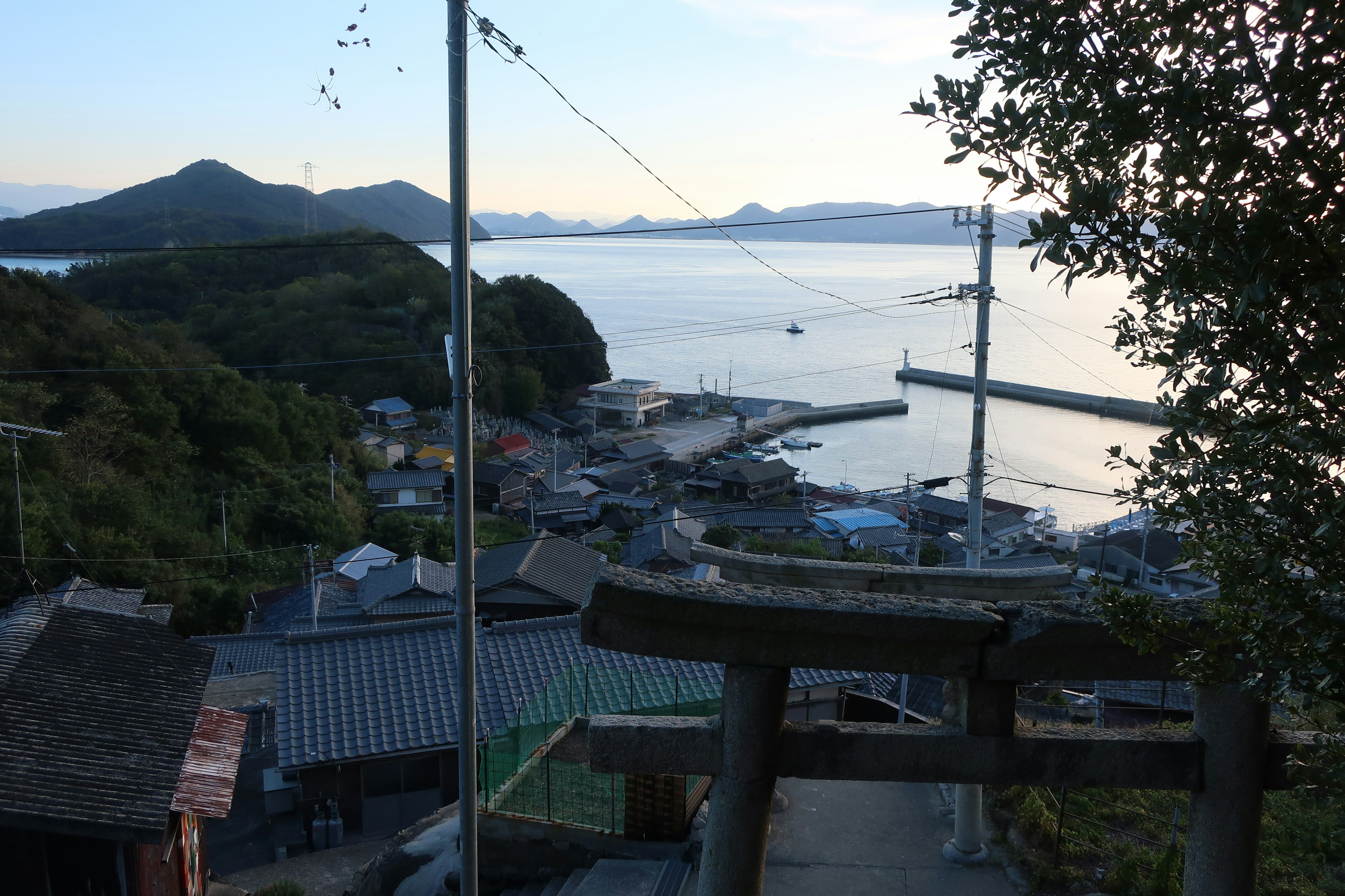 Vue d'un village côtier tranquille au crépuscule avec la mer et les montagnes