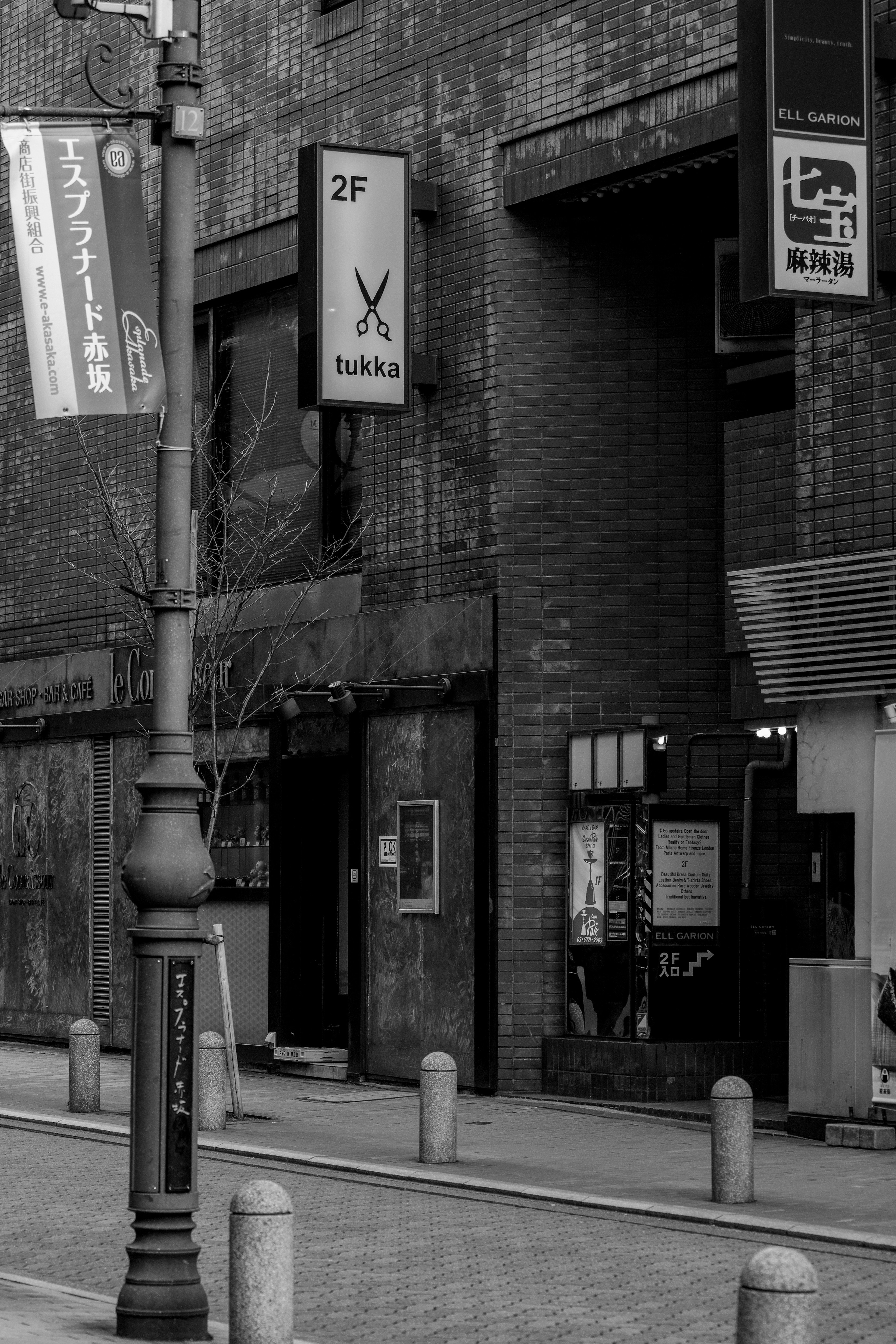 Scène de rue en noir et blanc avec une enseigne et l'extérieur d'un bâtiment