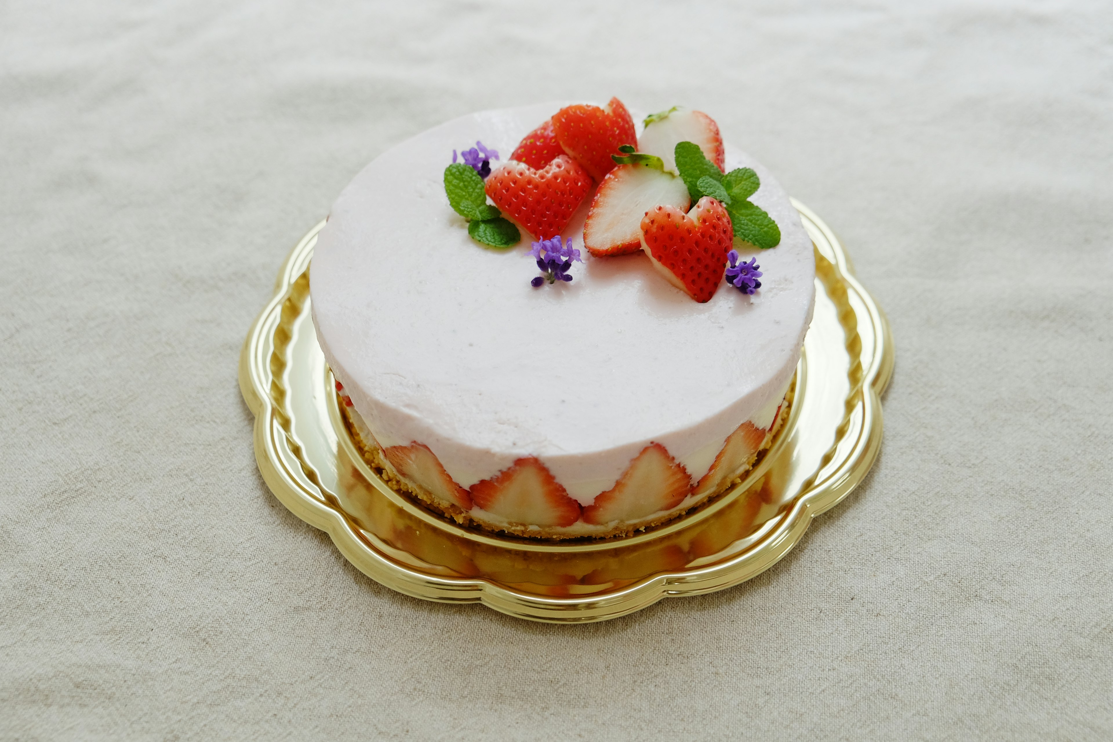 Pastel blanco decorado con fresas y hojas de menta