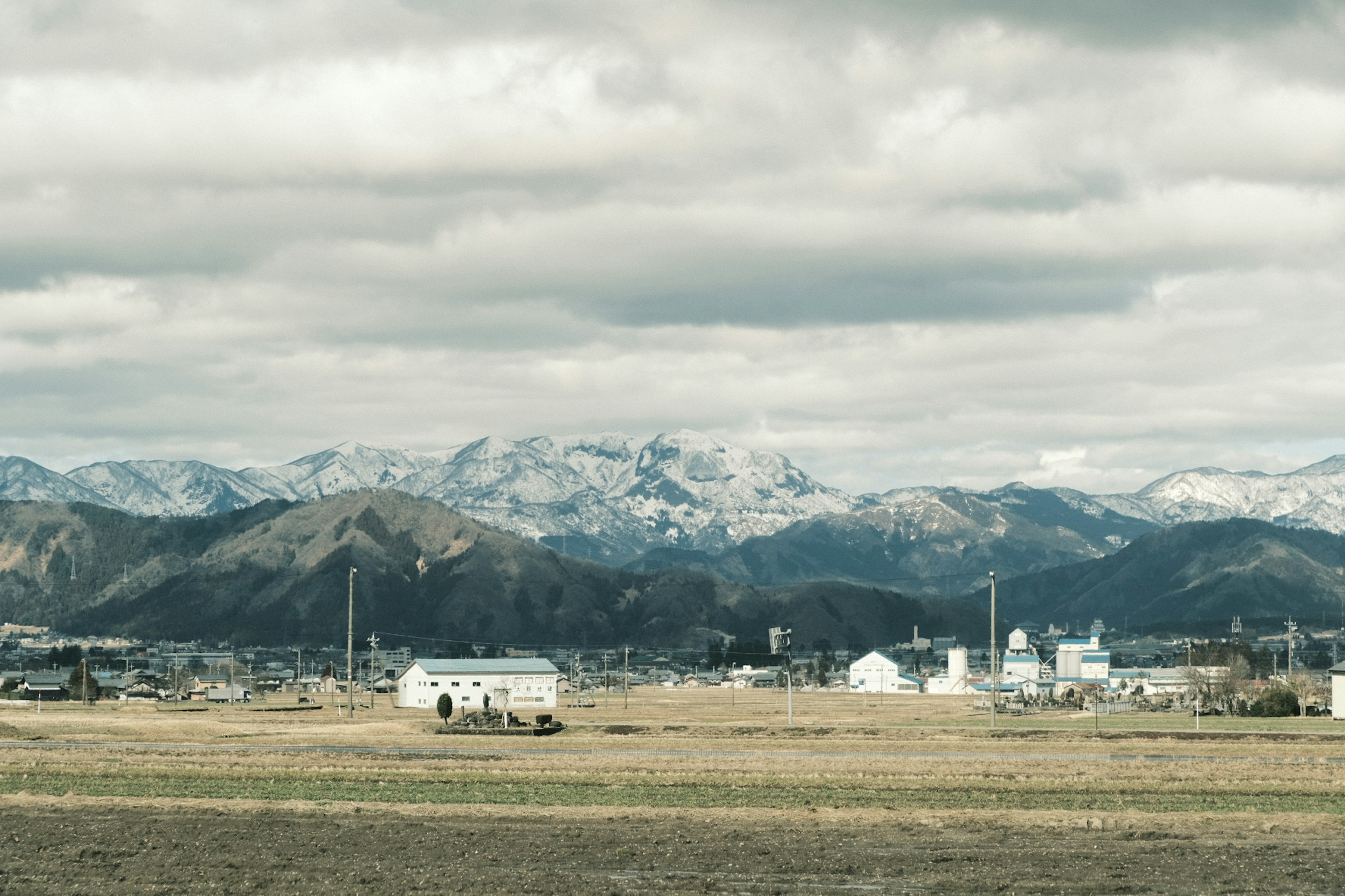 雪をかぶった山々と広がる草原の風景