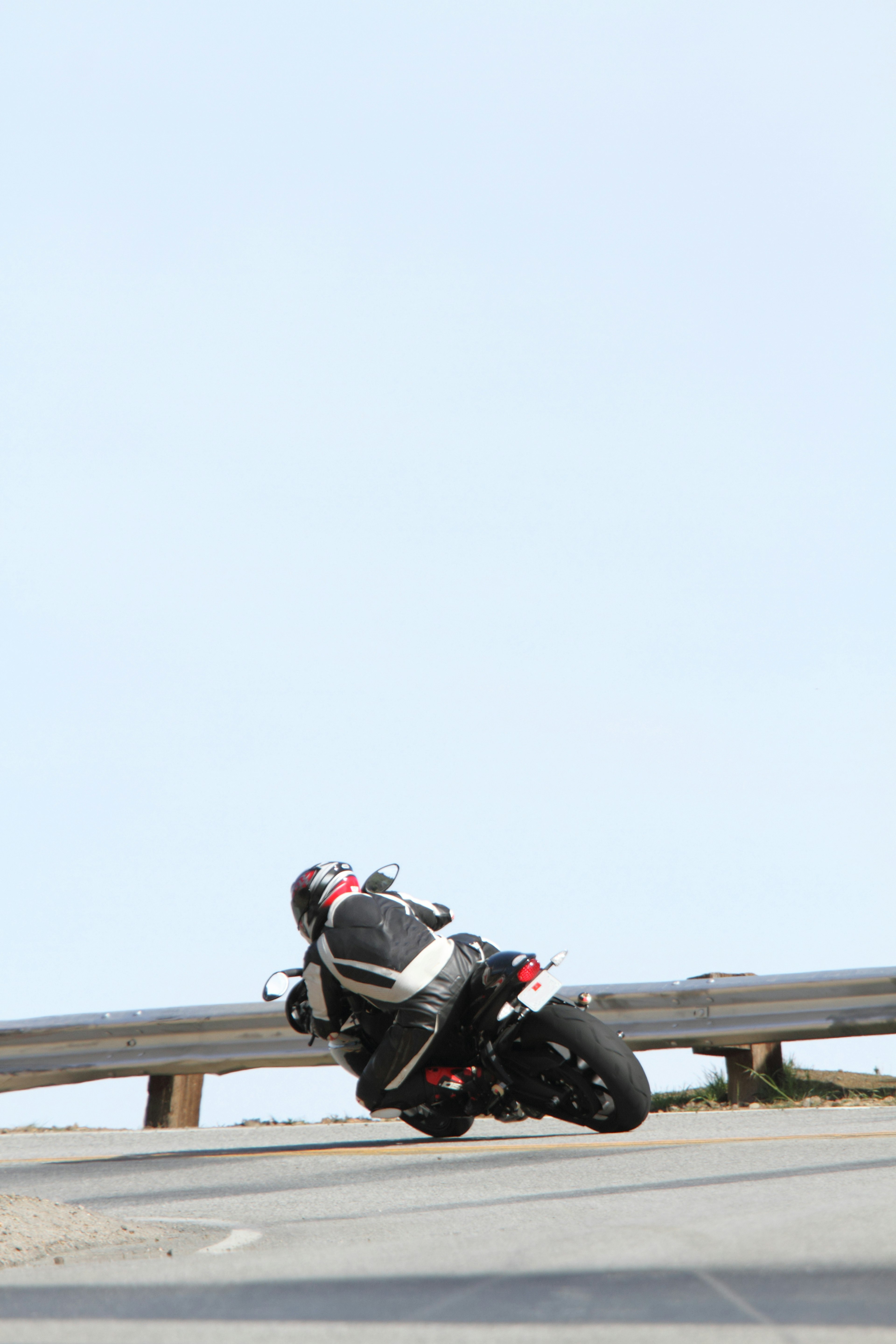 A motorcycle leaning into a curve on a winding road