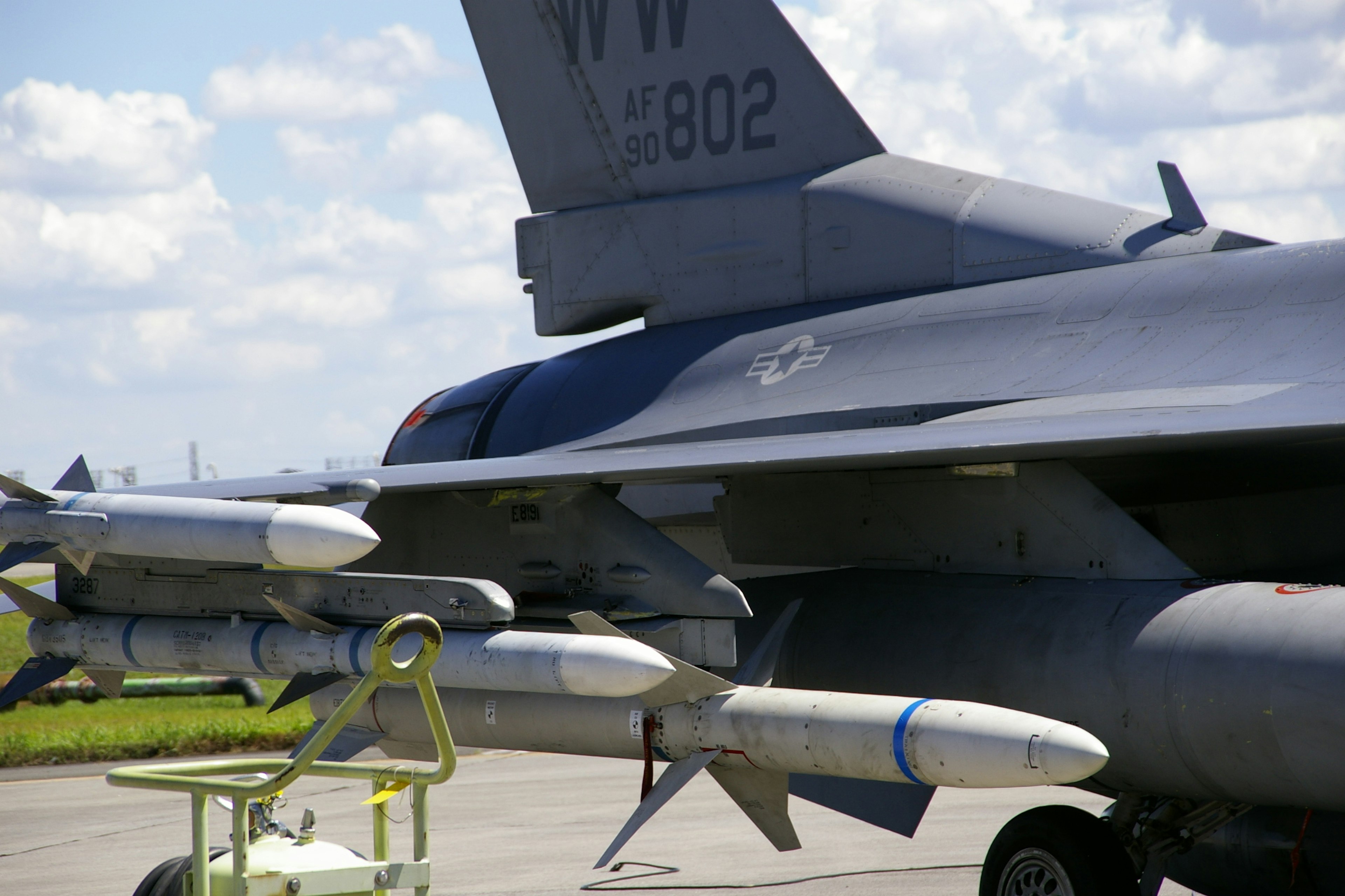 Side view of a military aircraft featuring missiles and tail wing