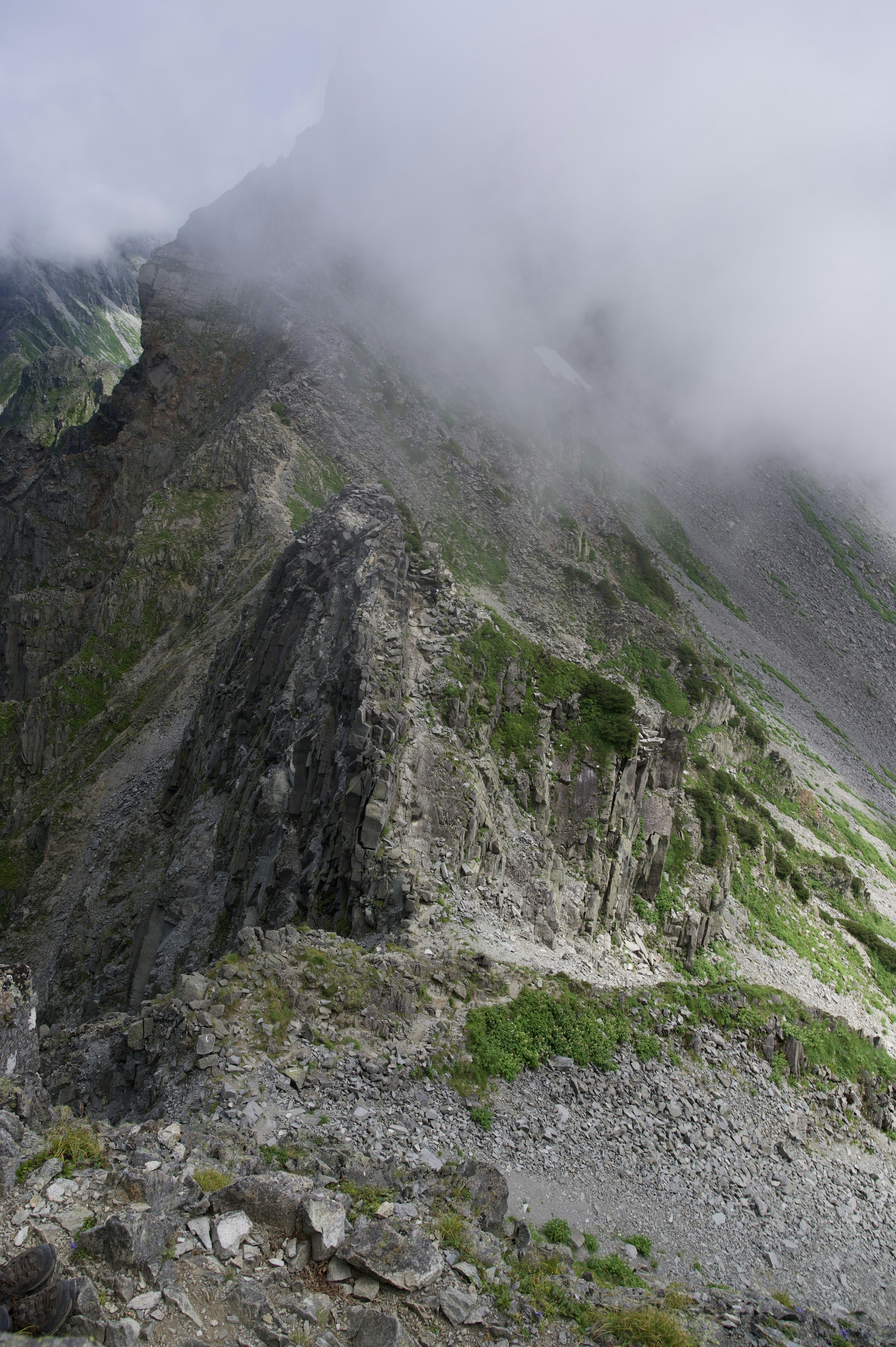 被雾笼罩的山景，陡峭的悬崖和绿色植被