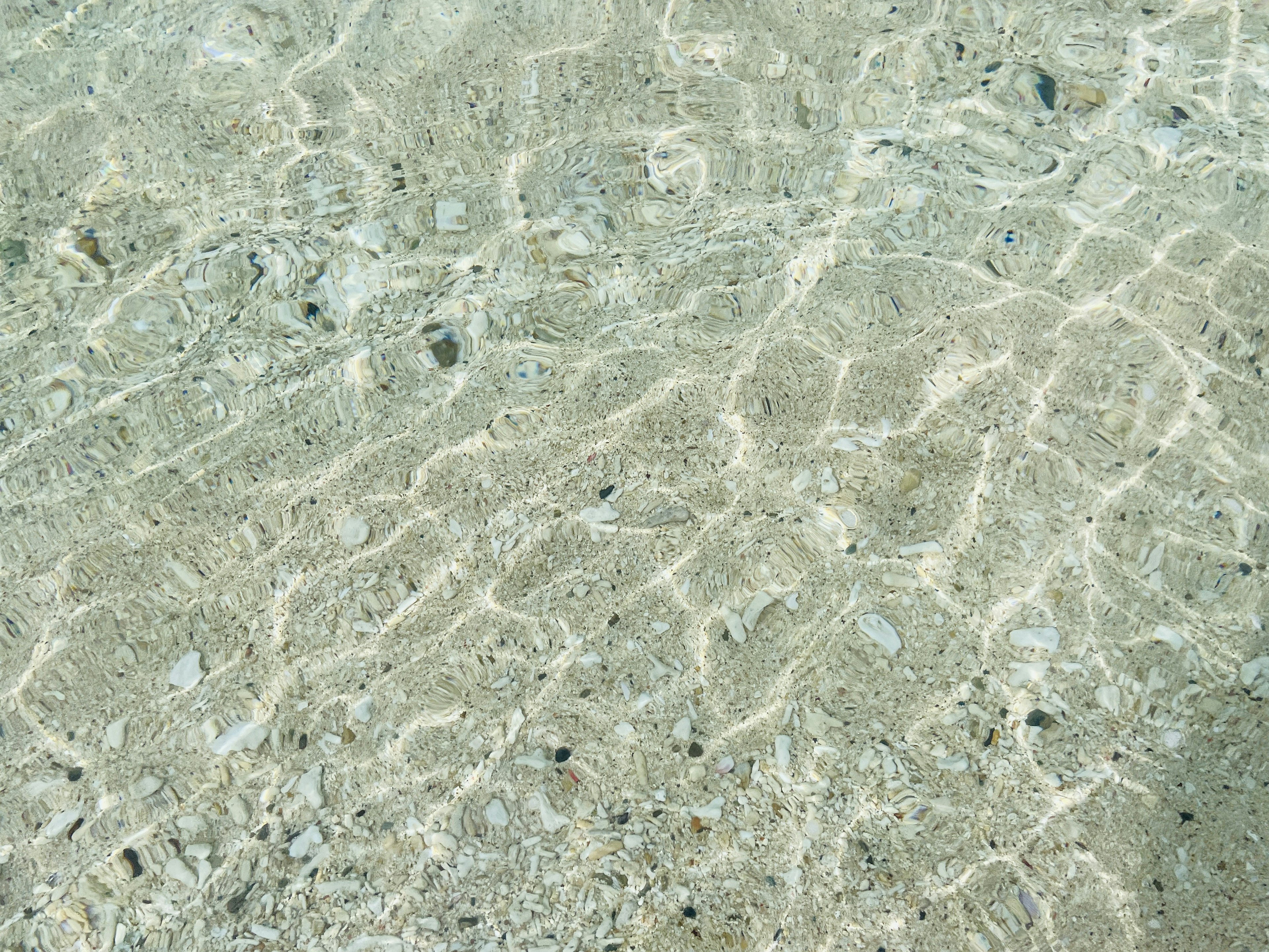 Clear water surface reflecting sandy bottom in a beautiful beach setting