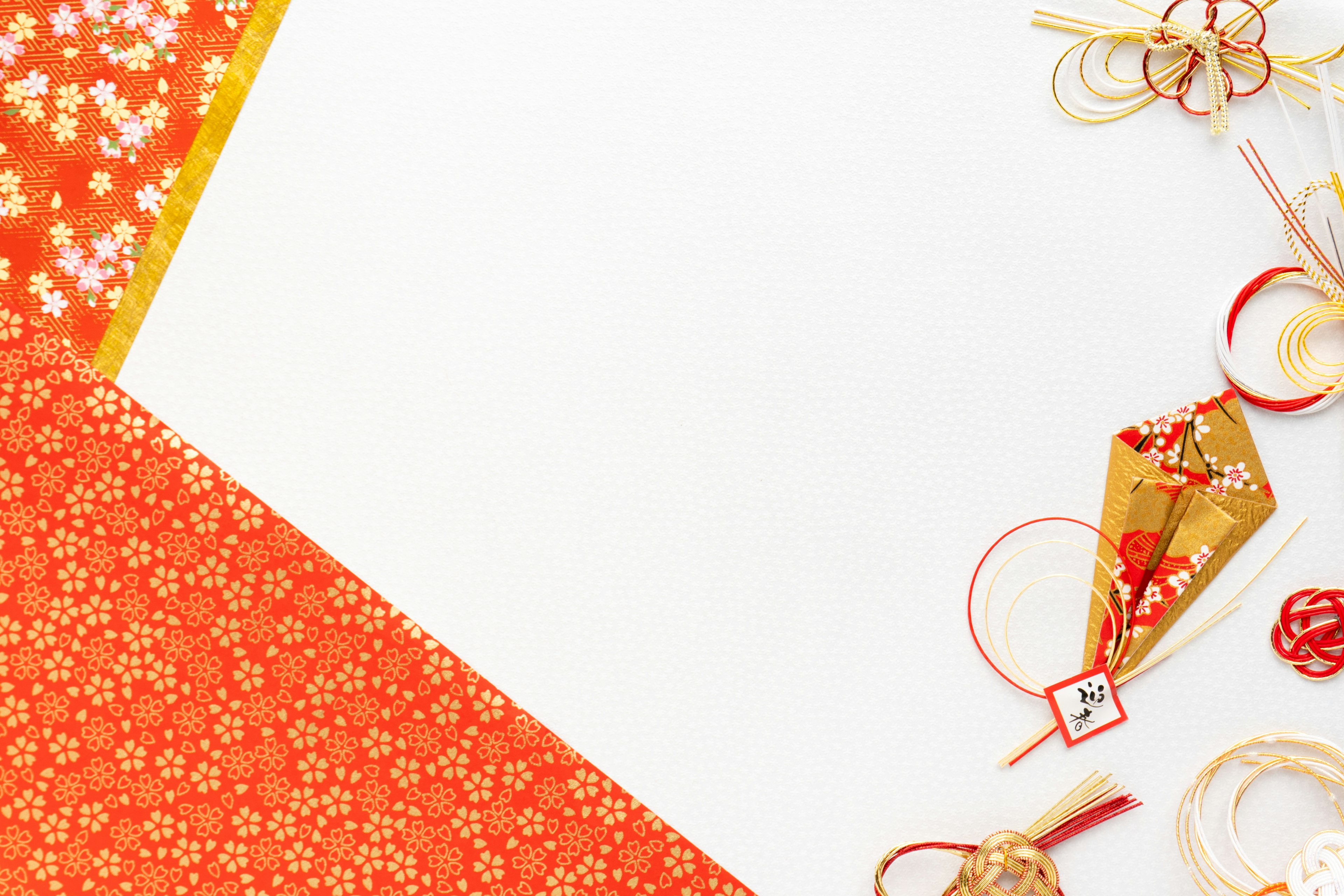 Red and orange patterned paper with decorative items on a white background