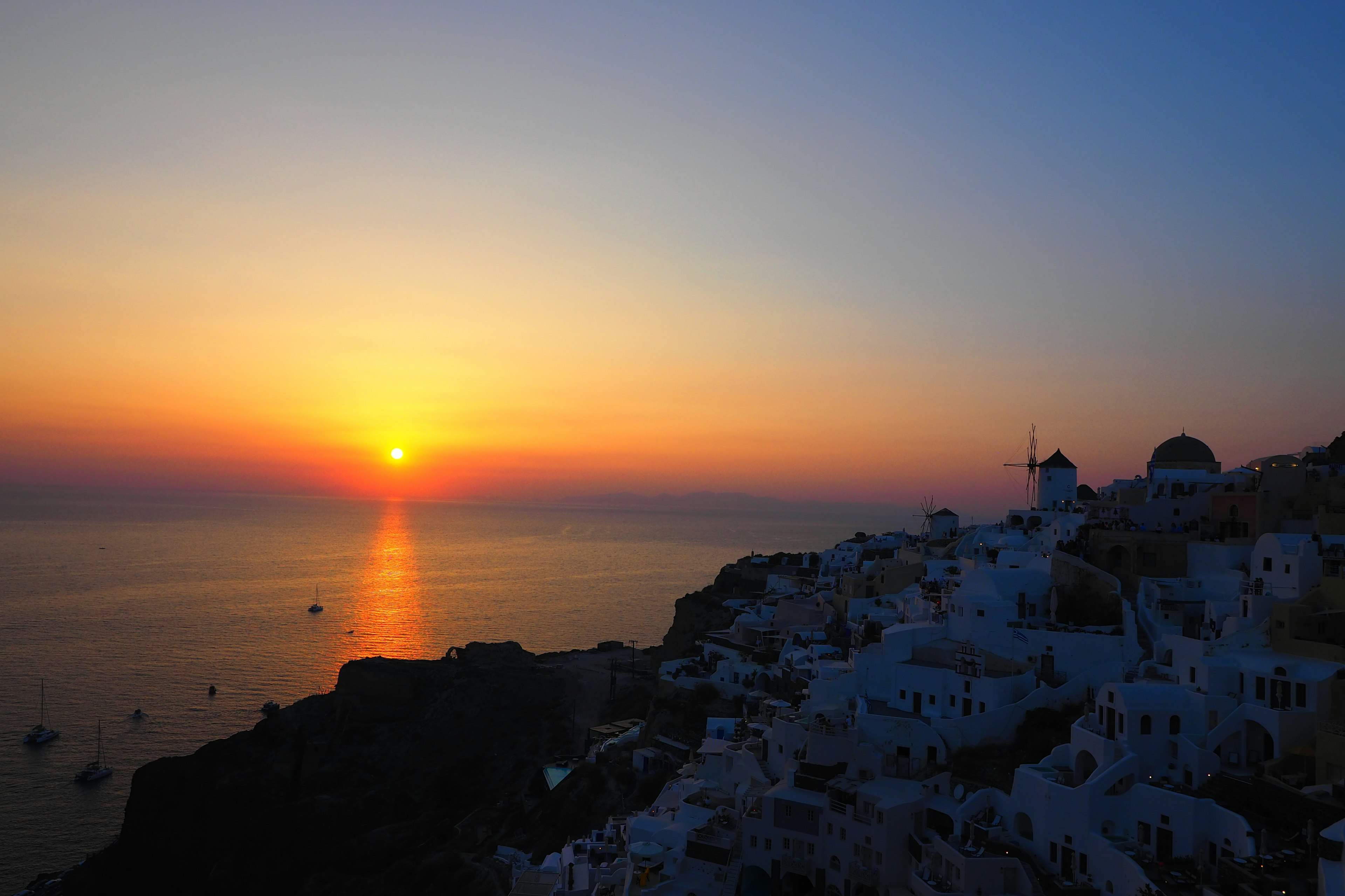 Impresionante atardecer sobre el mar con edificios blancos en Santorini