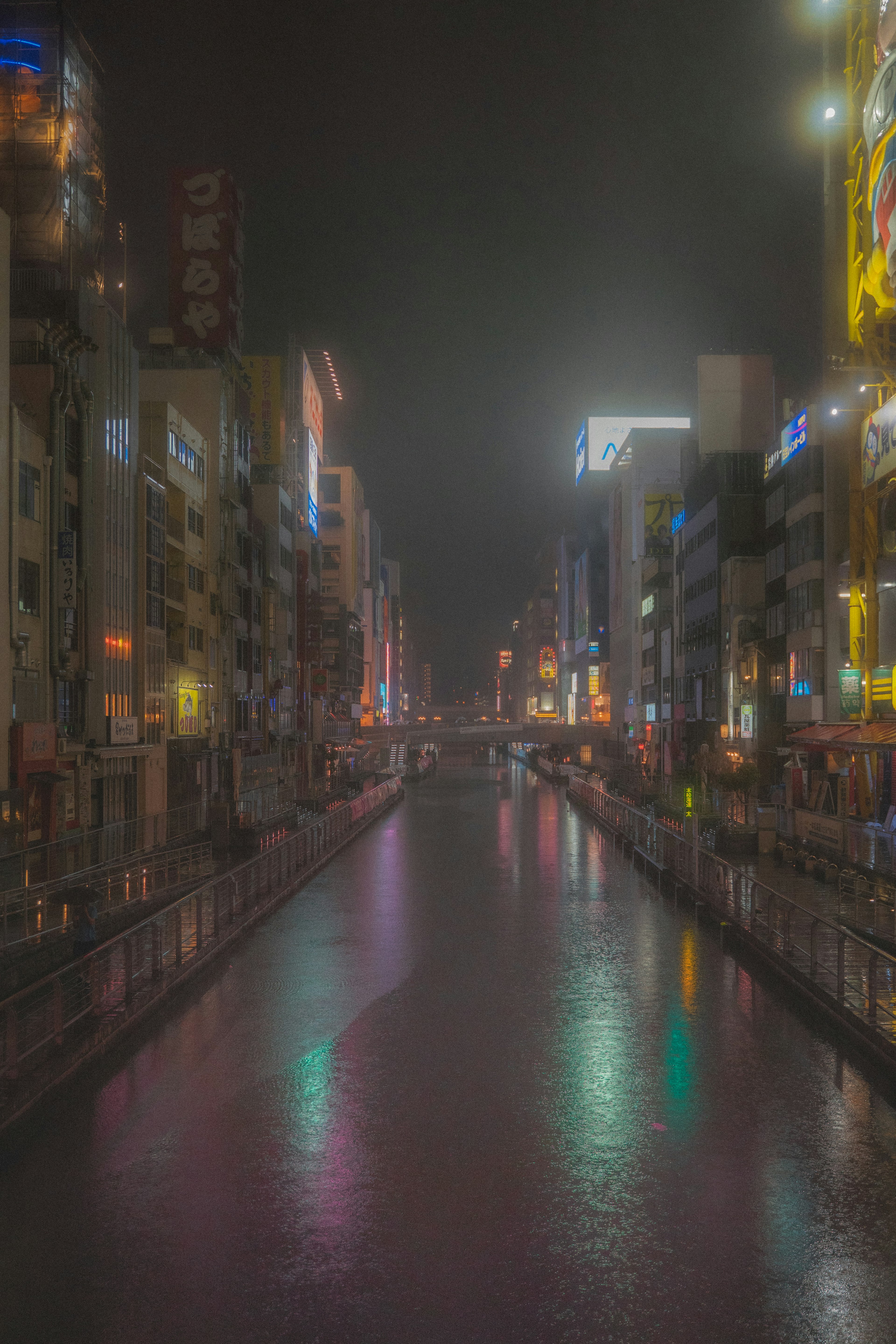 Paesaggio urbano notturno lungo il fiume con belle riflessioni al neon