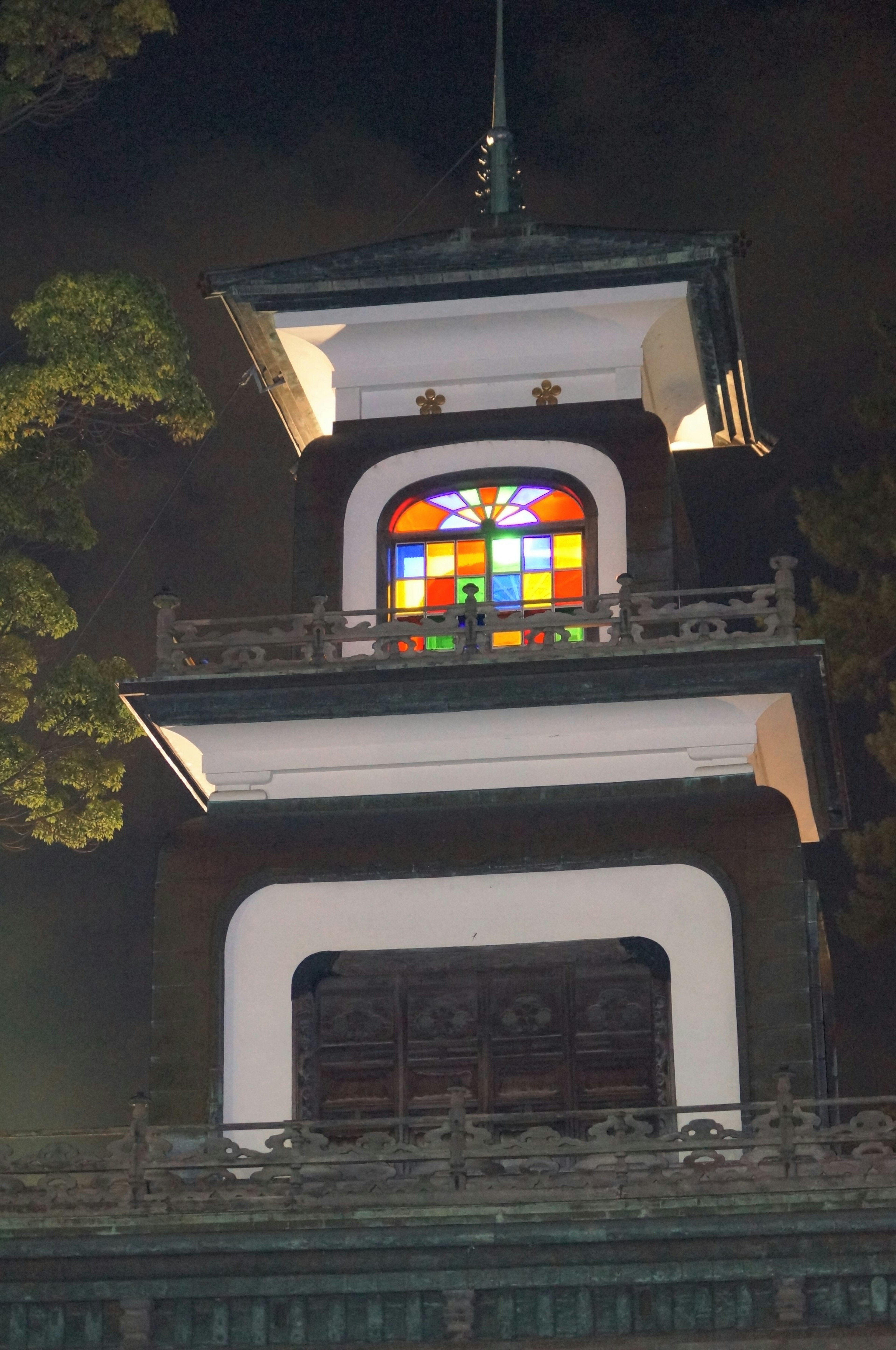 Colorful stained glass window on the upper part of a tower at night