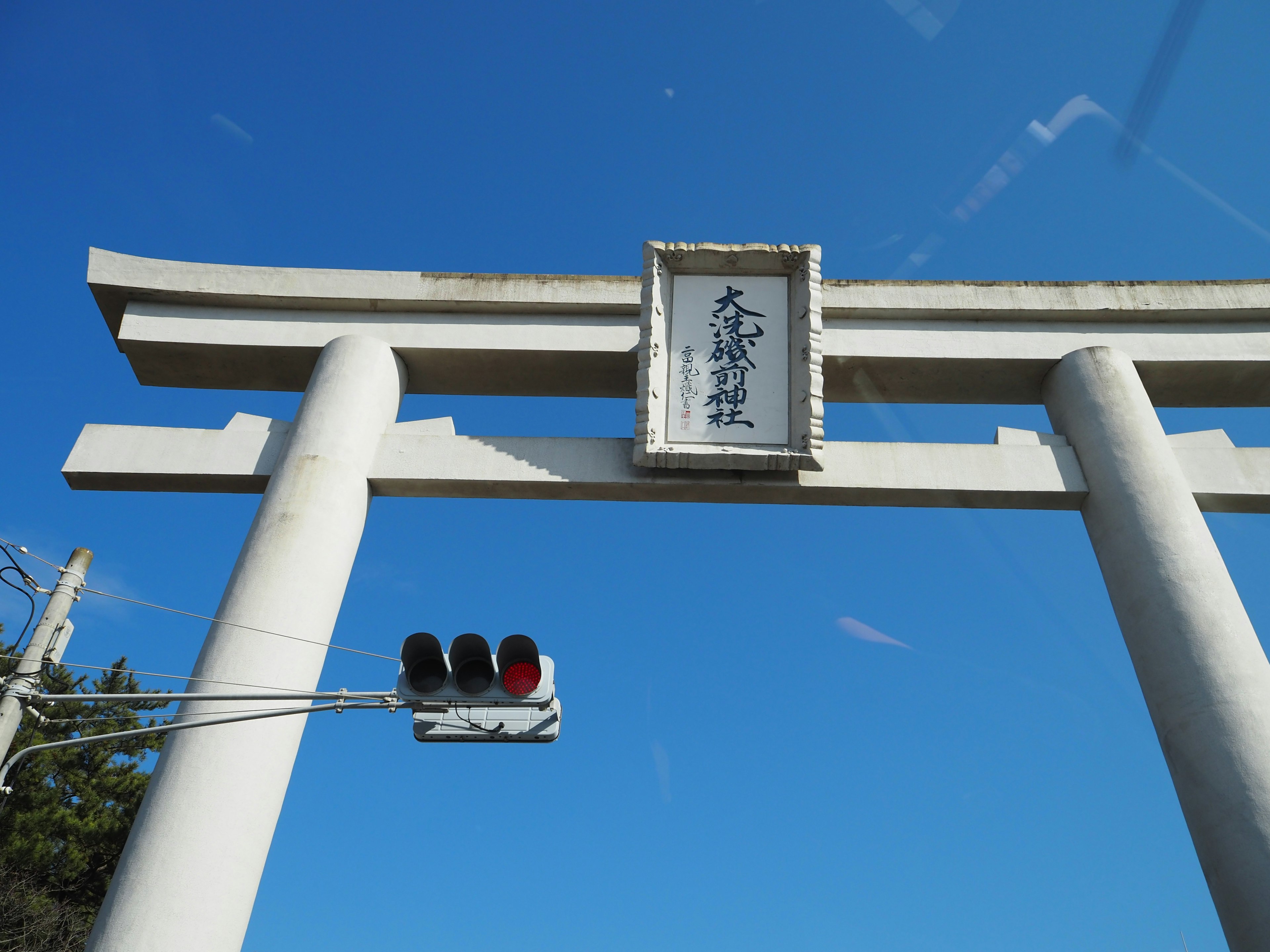 青空の下にある鳥居と信号機