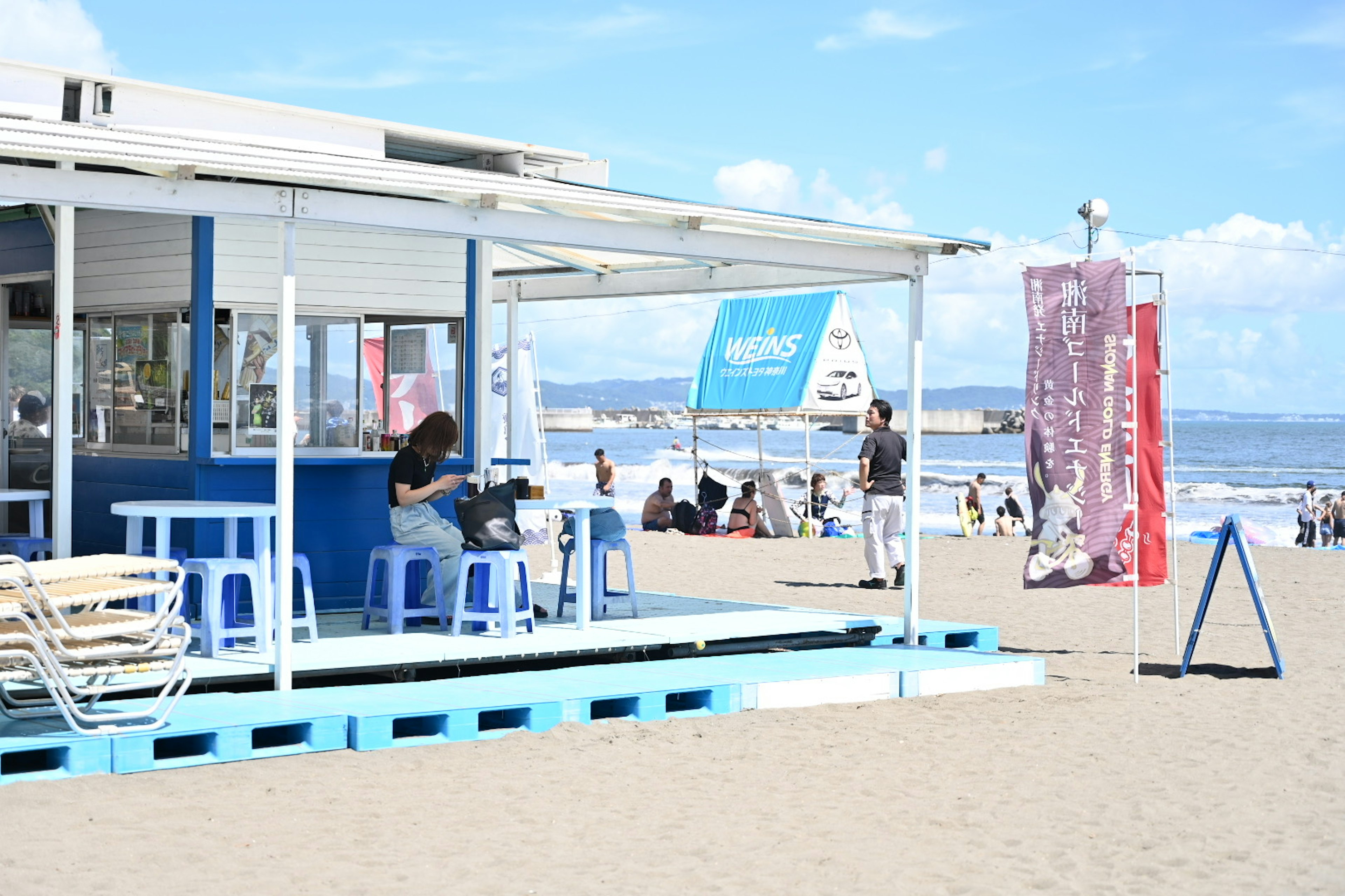 Café am Strand mit Menschen, die die Sonne genießen