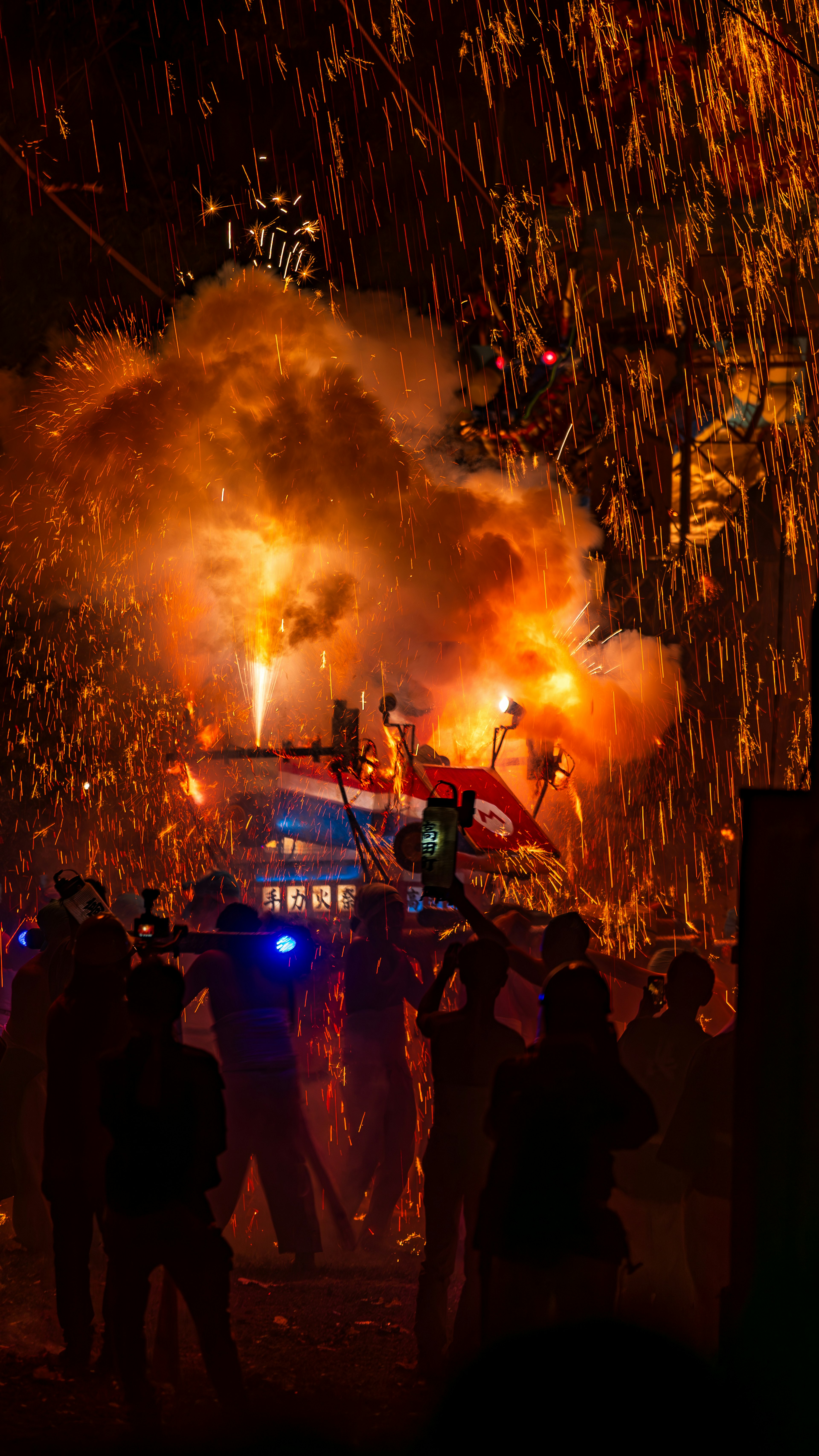 A vibrant festival scene with fireworks and sparks illuminating the night sky