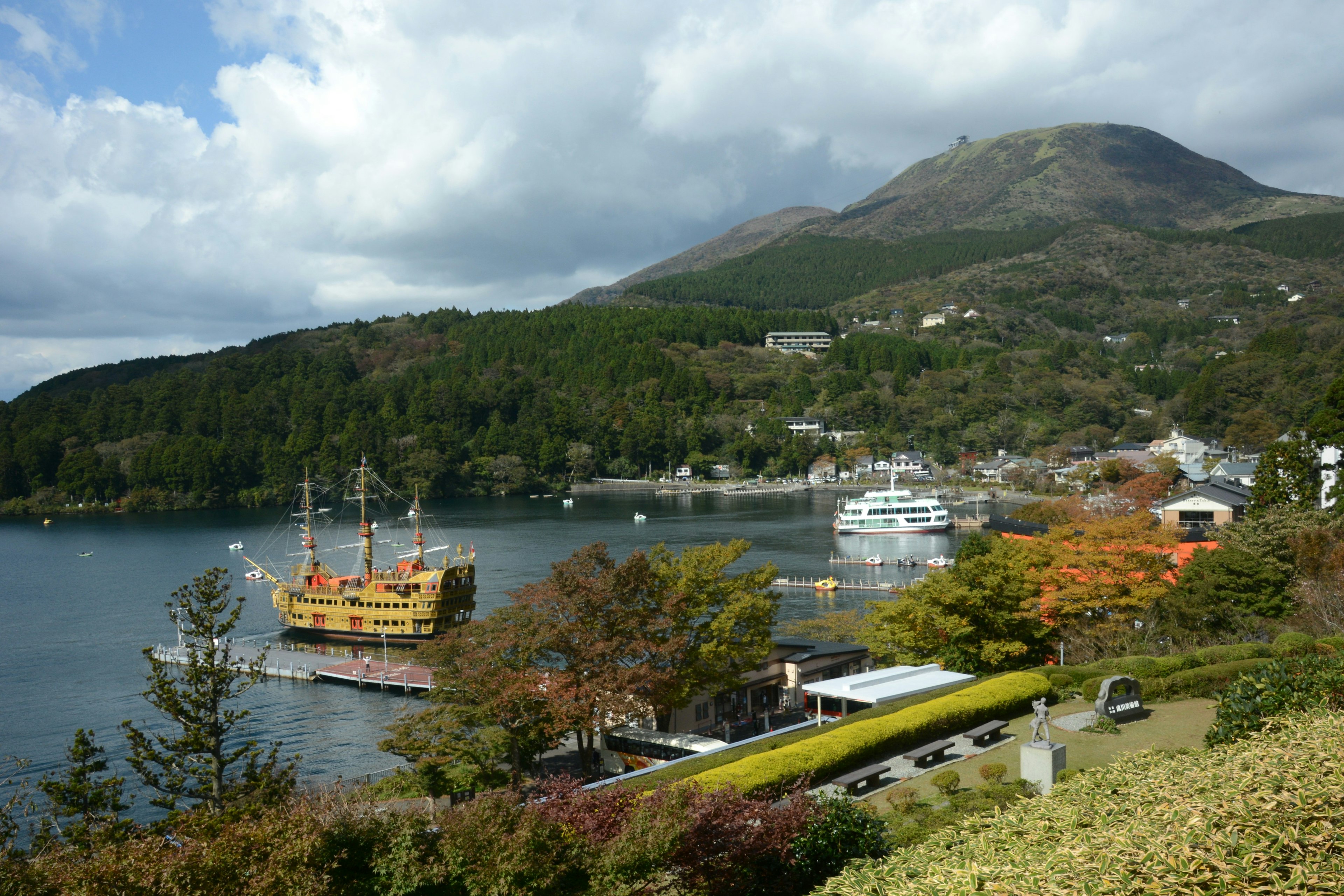 ทิวทัศน์ท่าเรือที่สวยงามพร้อมภูเขาเป็นฉากหลังและเรือสีส้ม