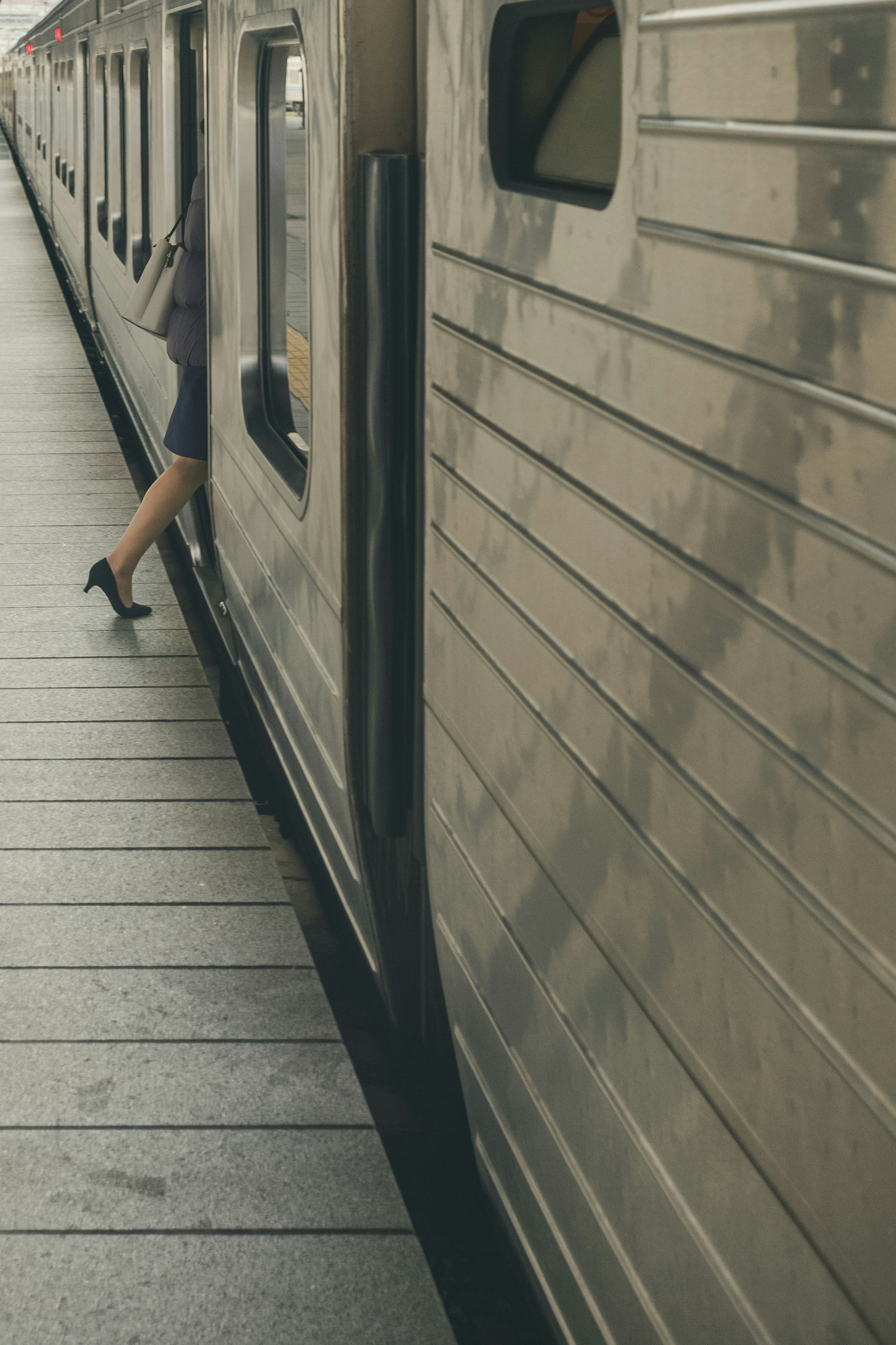 Une jambe de femme sortant d'un train avec une surface métallique brillante