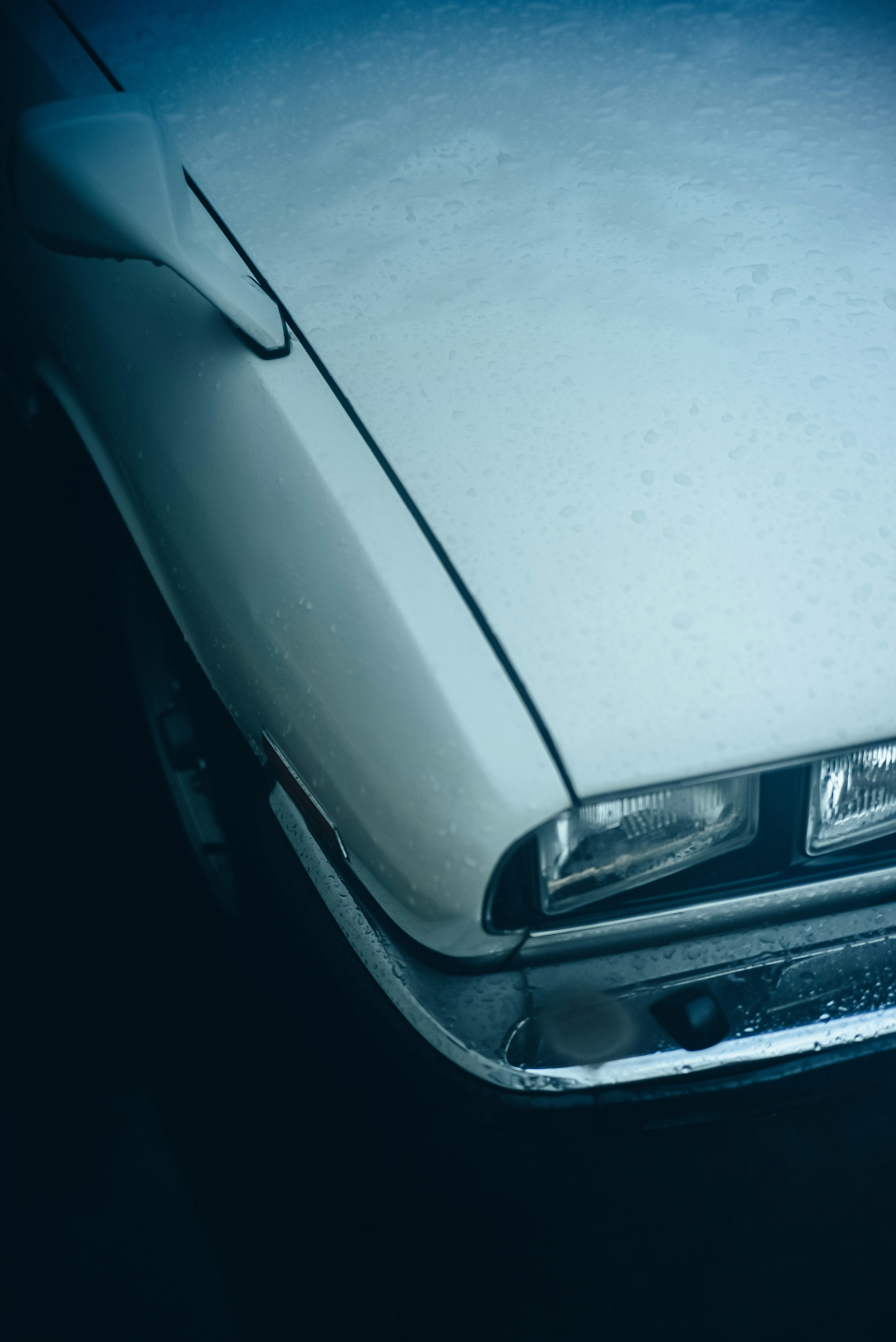 Gros plan sur une voiture classique blanche partiellement mouillée