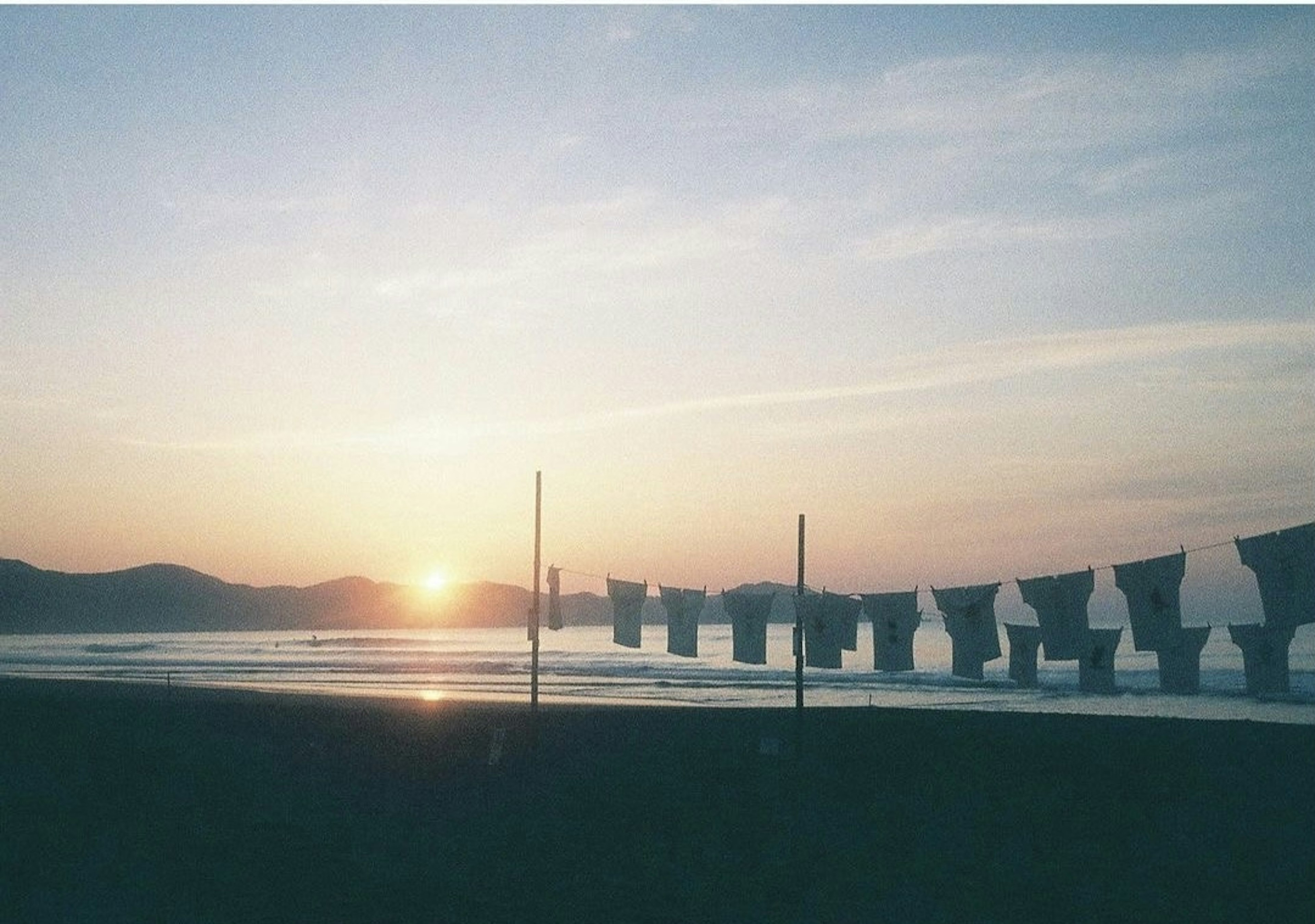 海辺の夕日とシルエットの椅子が並ぶ風景