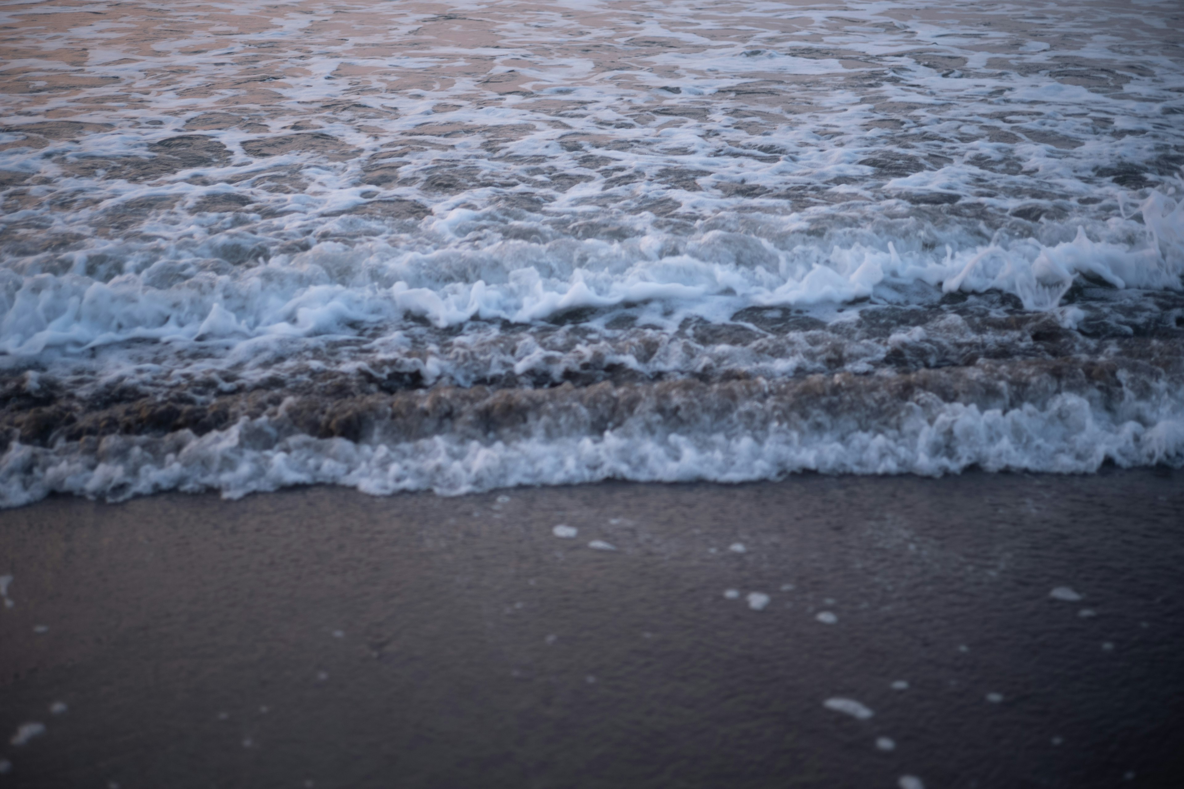 Vagues se brisant doucement sur une plage de sable