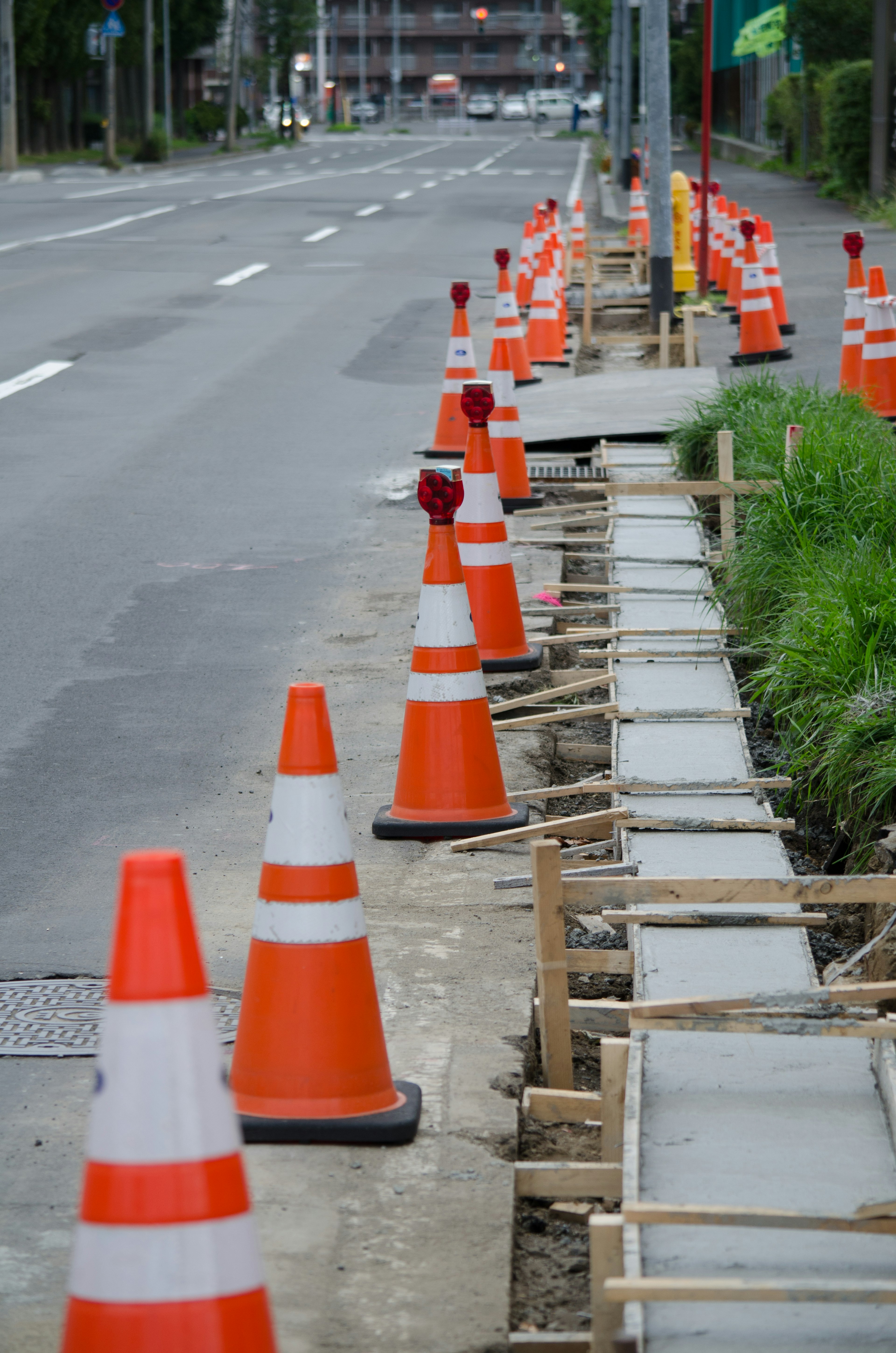 Orange traffic cones lining a sidewalk under construction