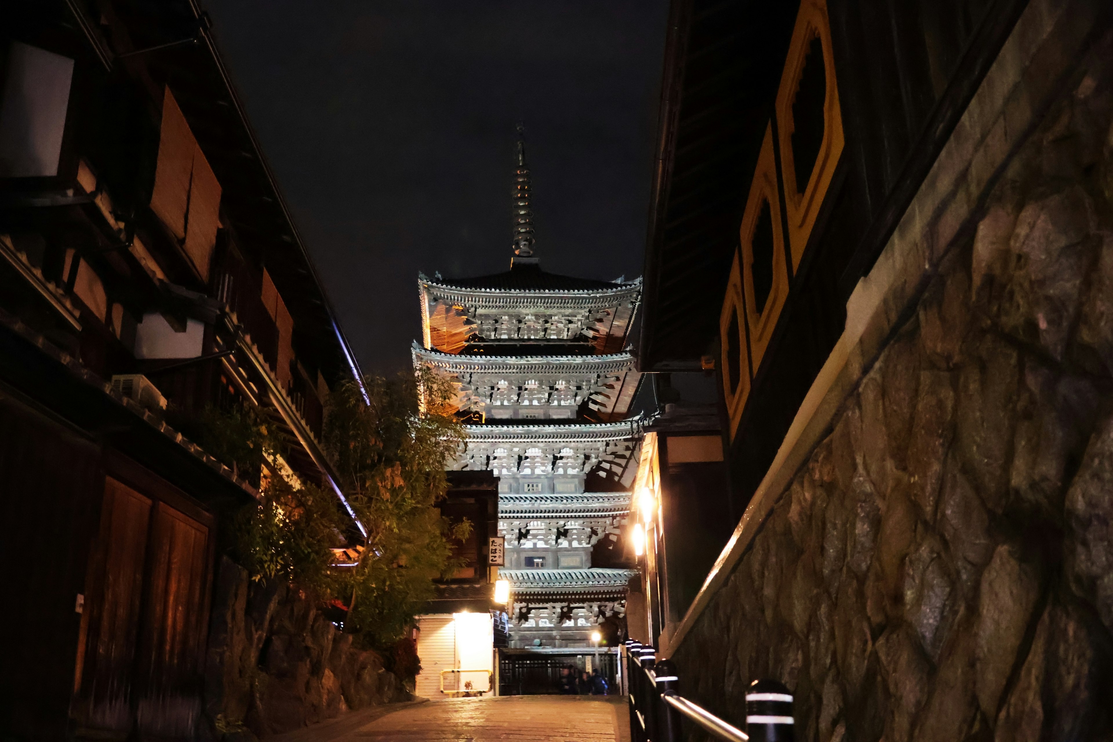 A beautiful pagoda towering over a nighttime street with traditional buildings