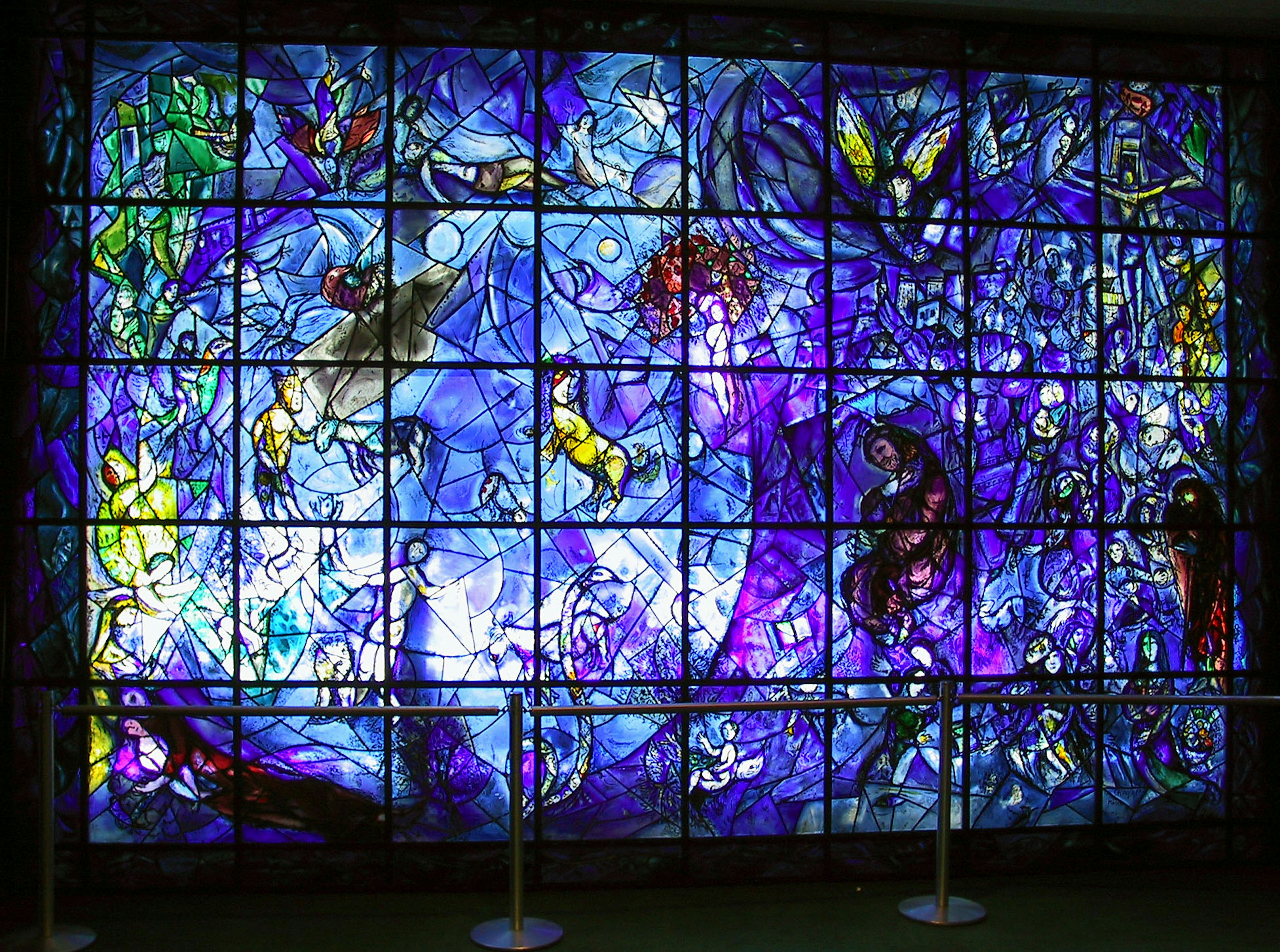 Beautiful stained glass mural in shades of blue and purple featuring intricate designs