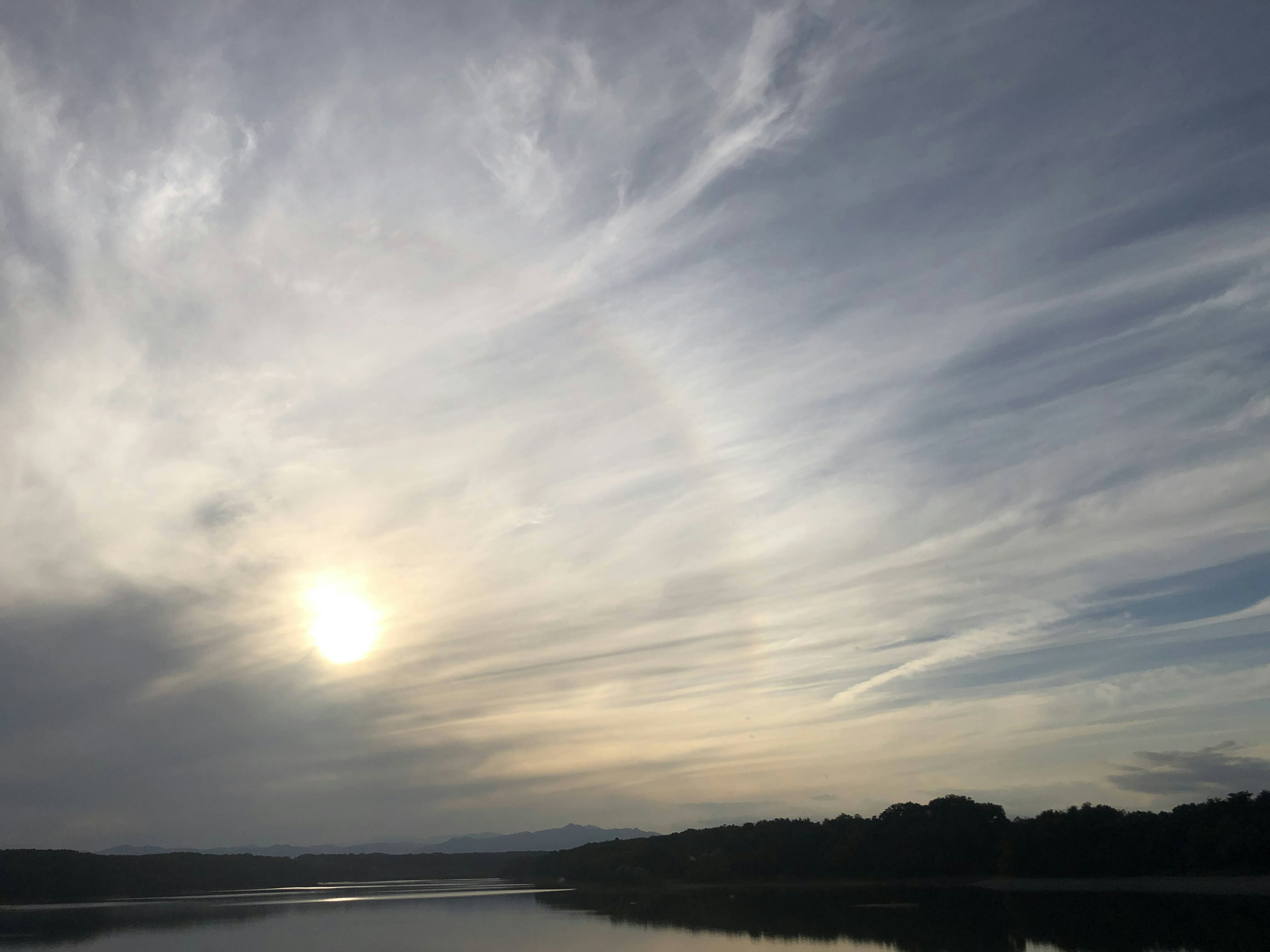 Lago sereno con nubes majestuosas al atardecer