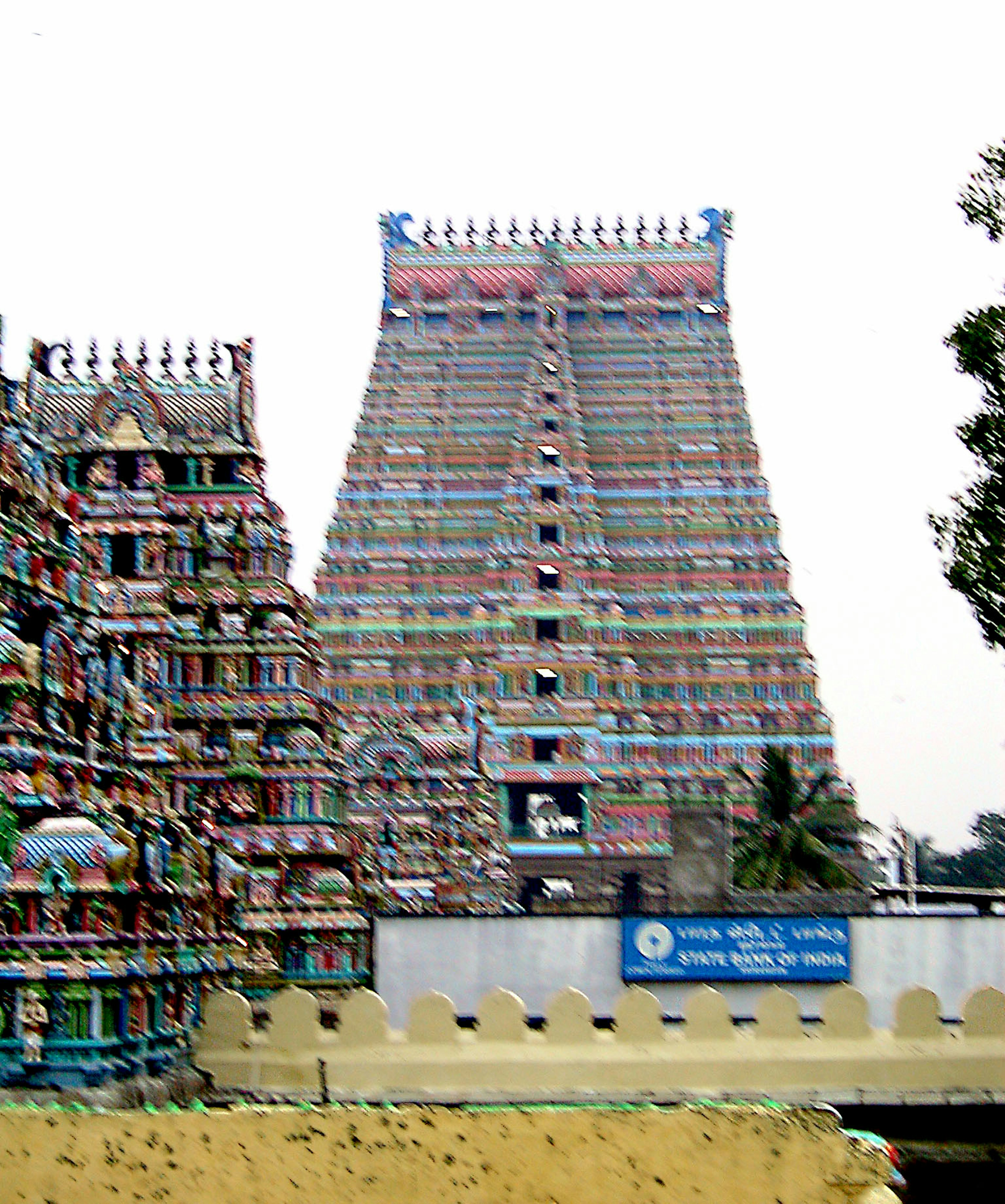 Colorful temple tower with intricate sculptures and adjacent structures