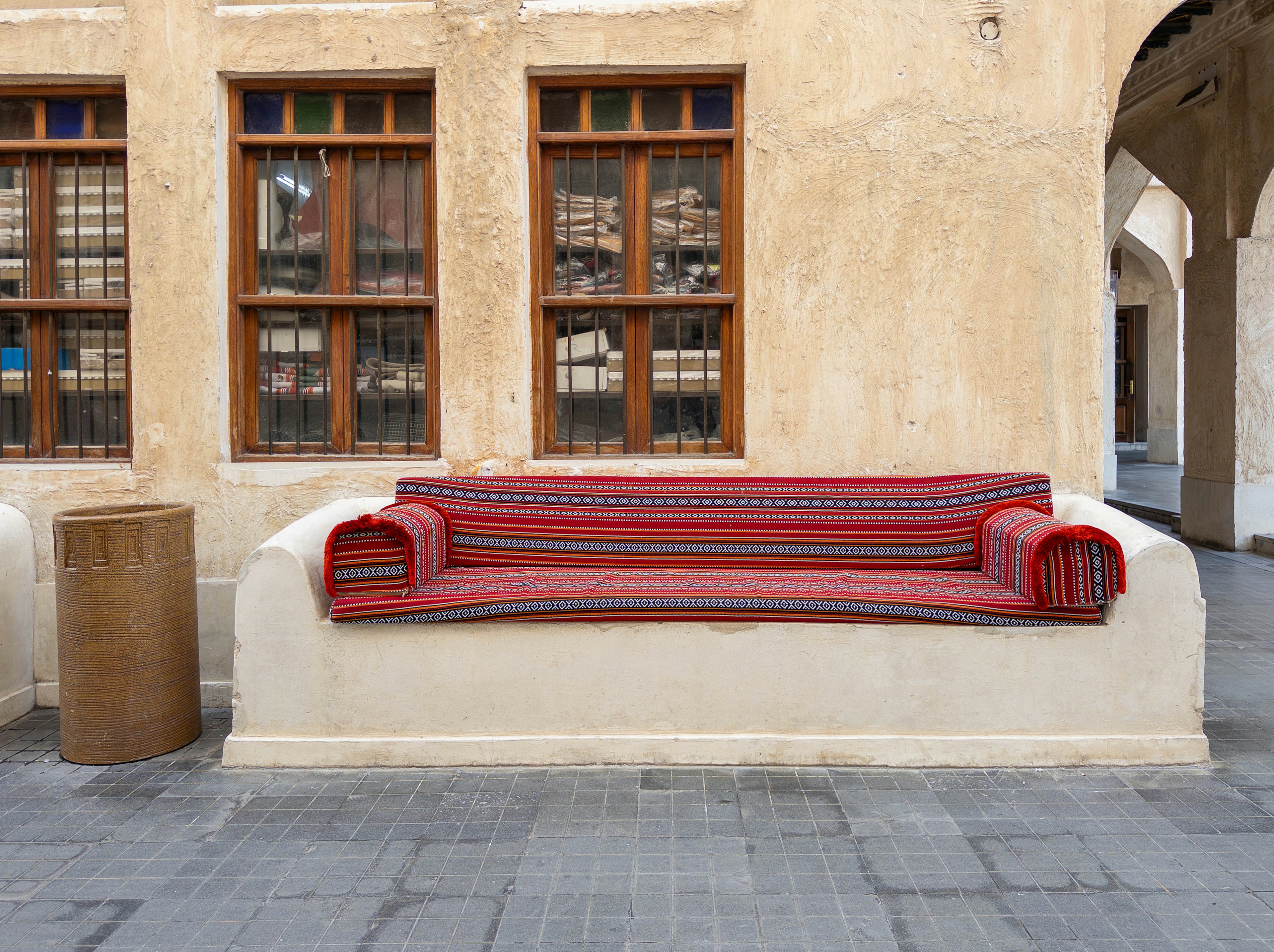 Canapé rayé rouge contre un mur texturé