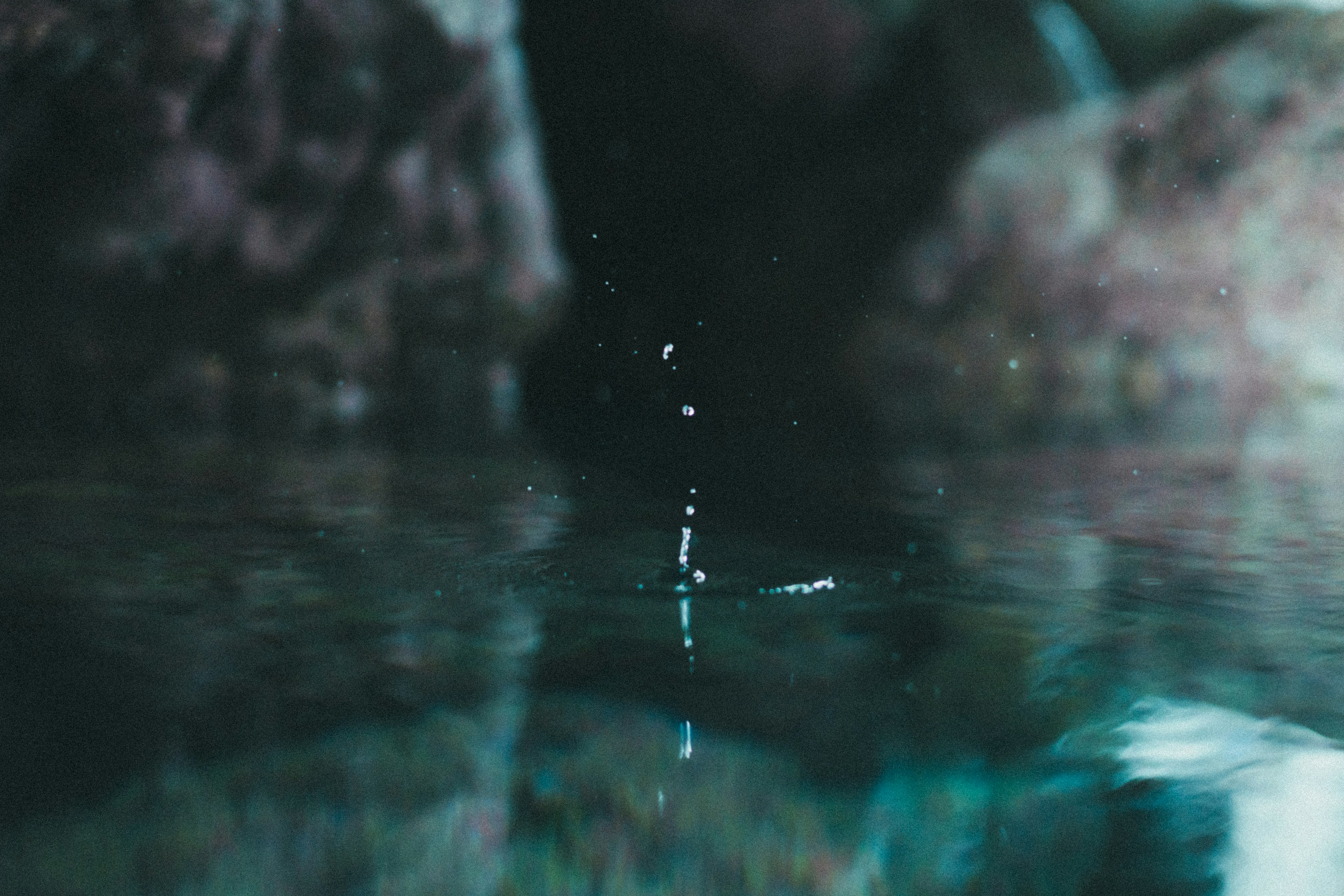 Une scène tranquille avec des gouttes tombant sur la surface de l'eau et leurs reflets