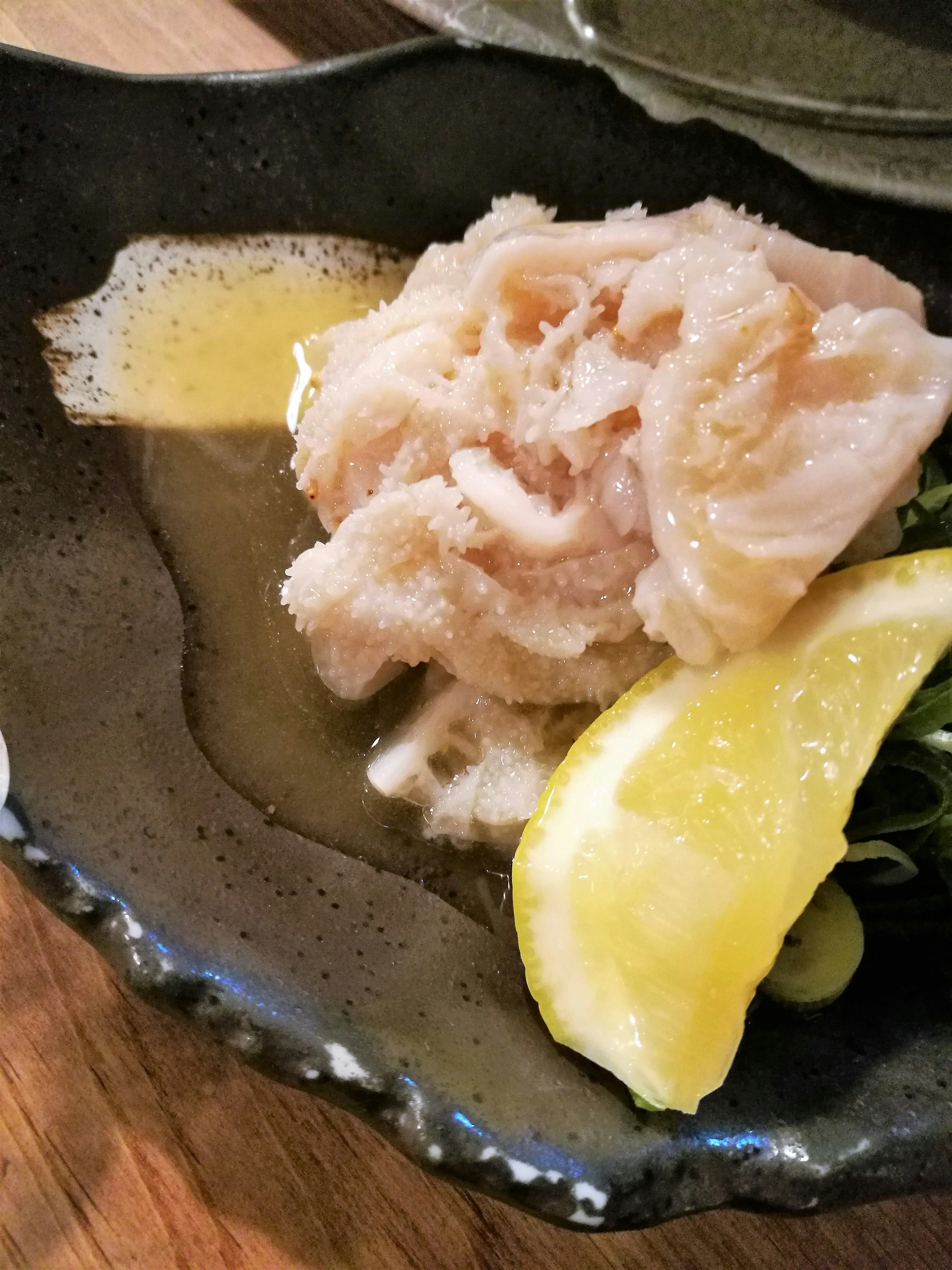 Sashimi of white fish served with lemon slices