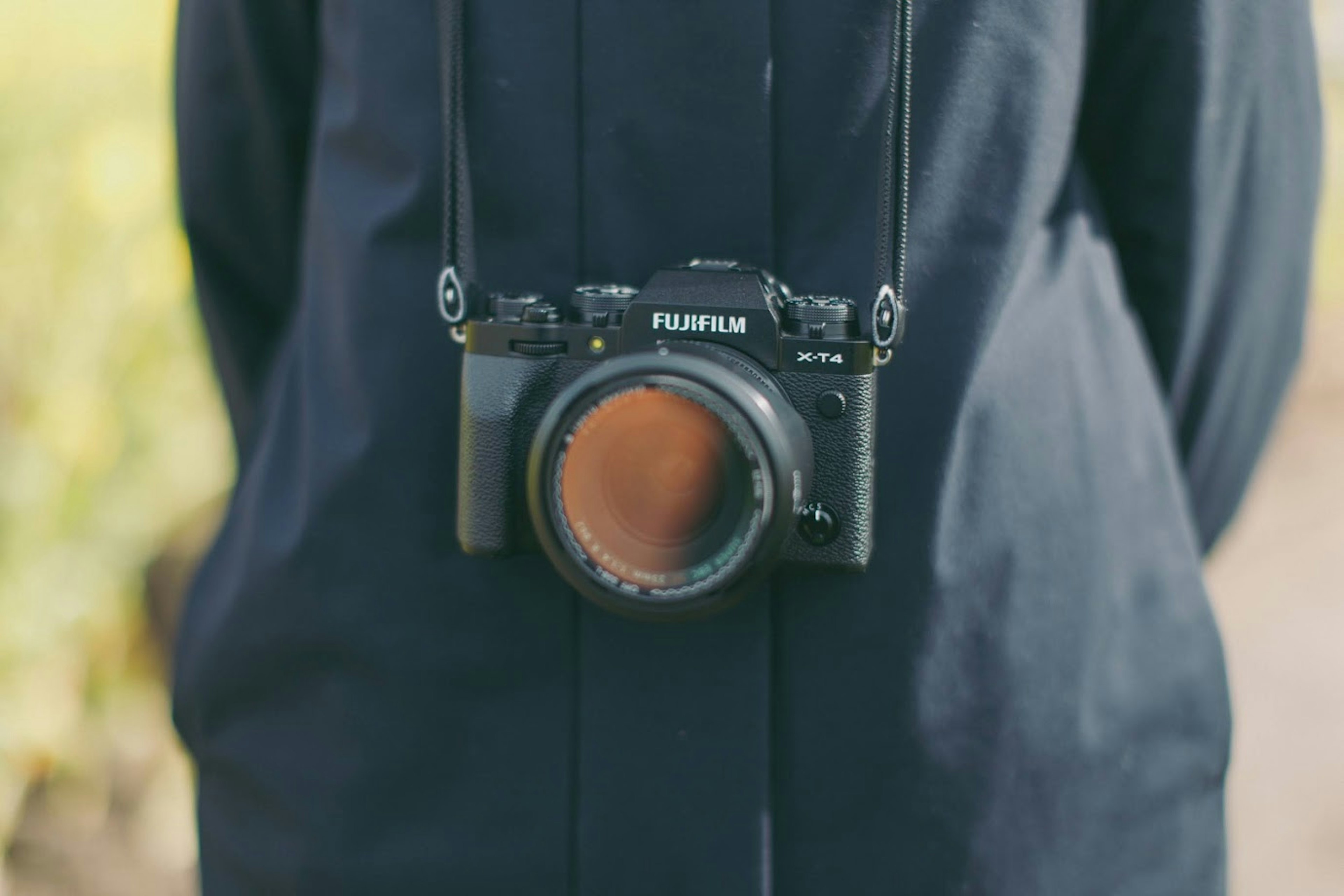 Macchina fotografica Fujifilm appesa al petto di una persona con un cappotto nero