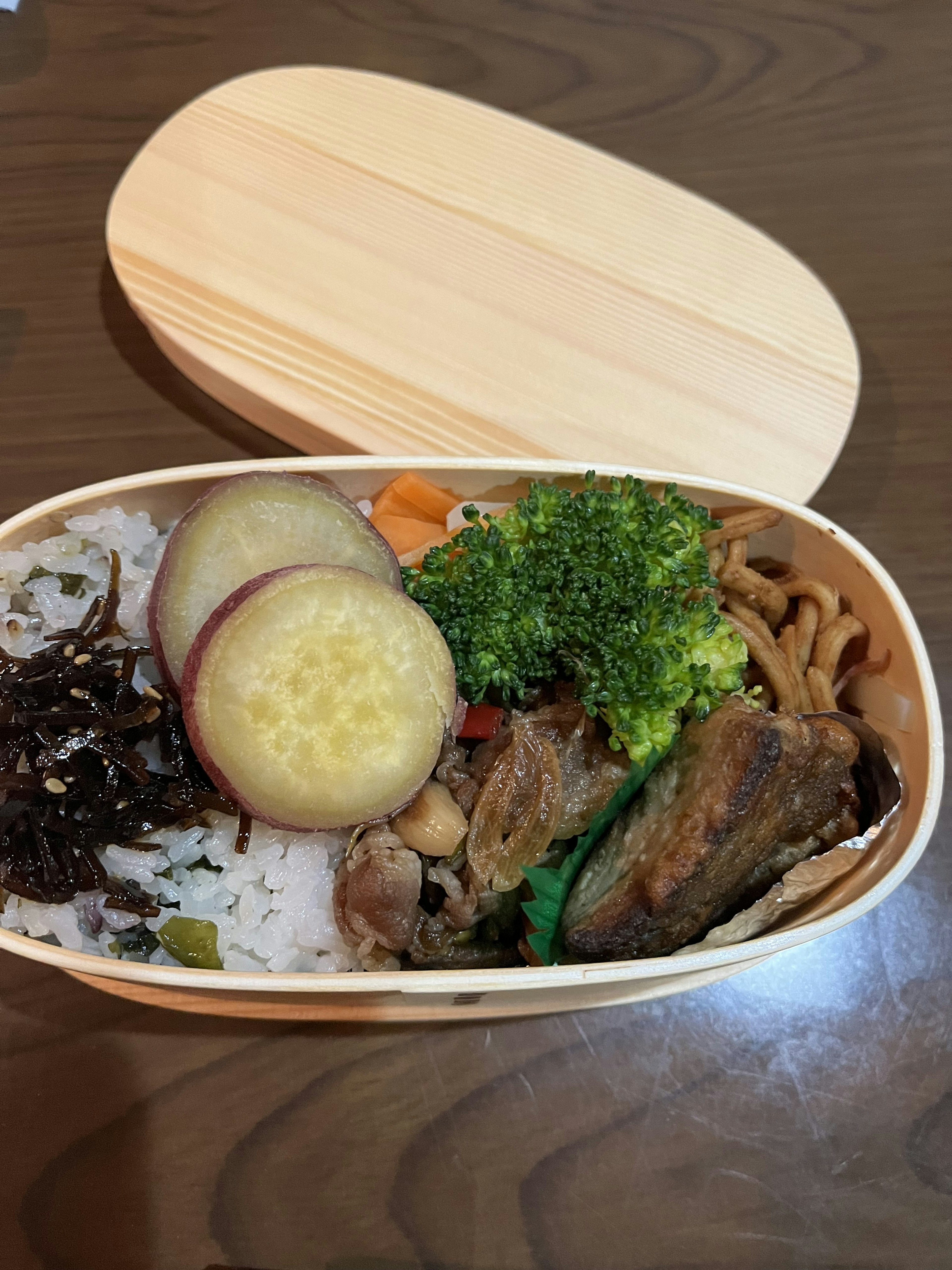 Una scatola bento piena di riso, verdure e piatti di carne