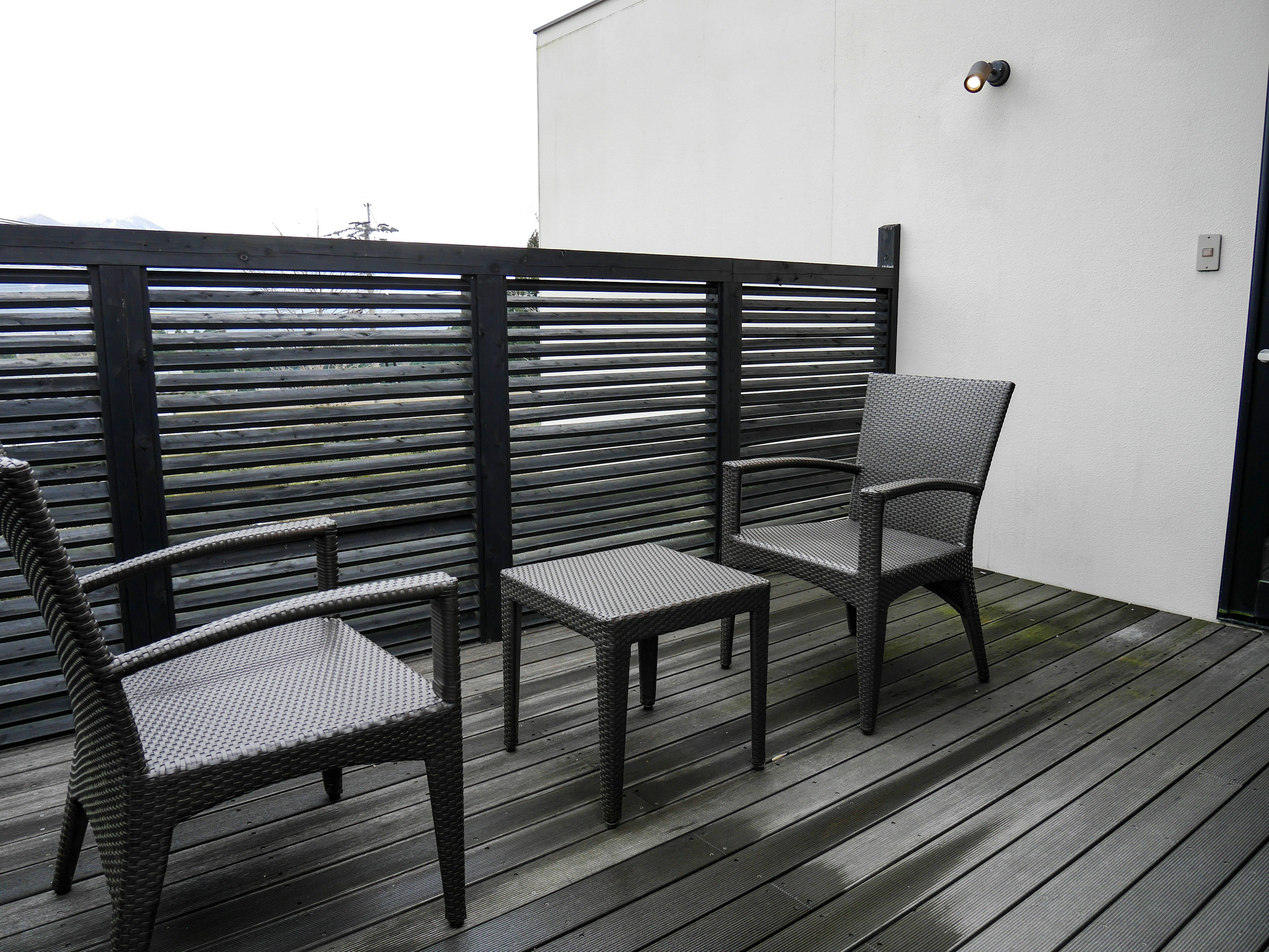 Deux chaises et une table sur un balcon extérieur