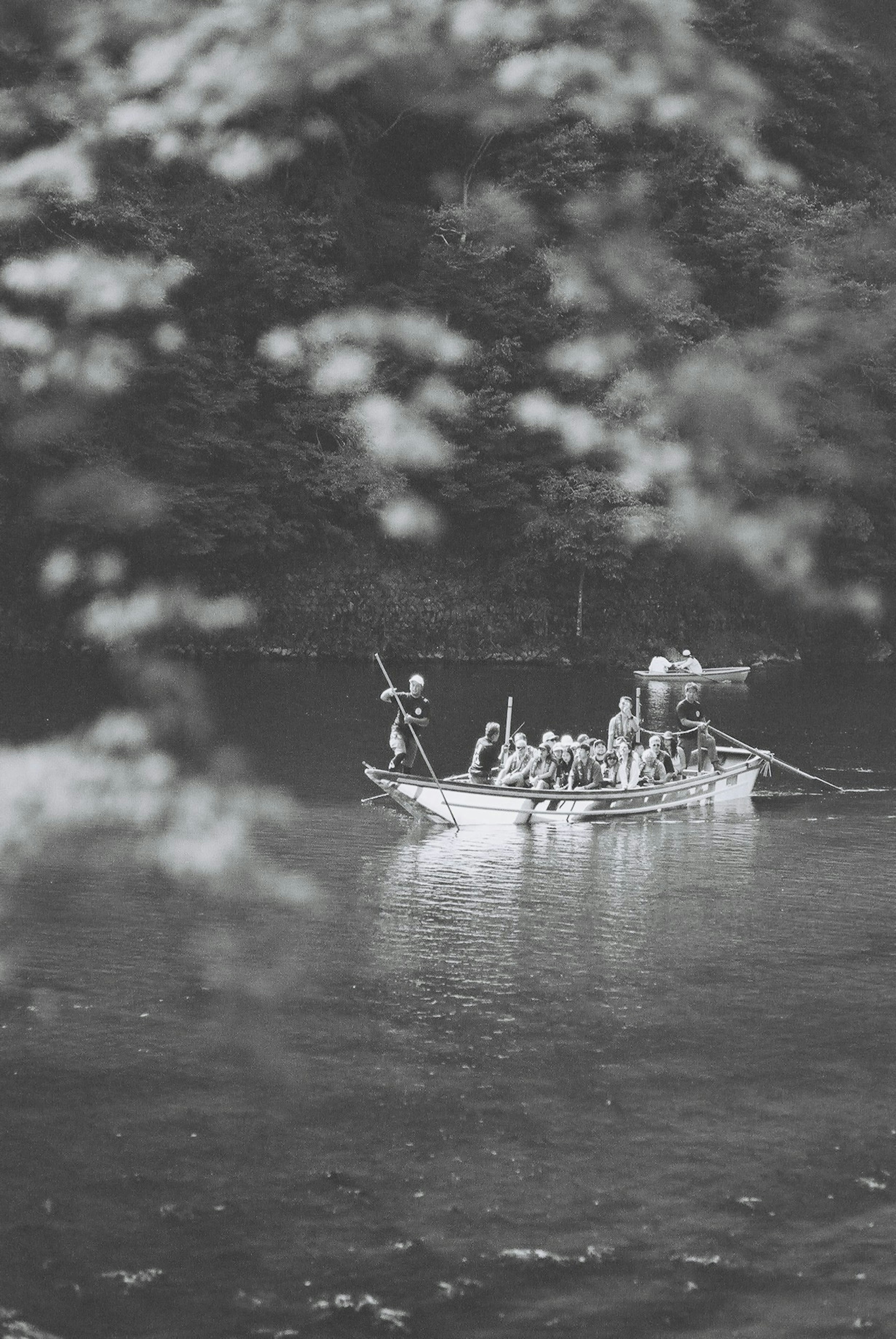 Gruppe von Menschen in einem Boot im Fluss Schwarzweißlandschaft