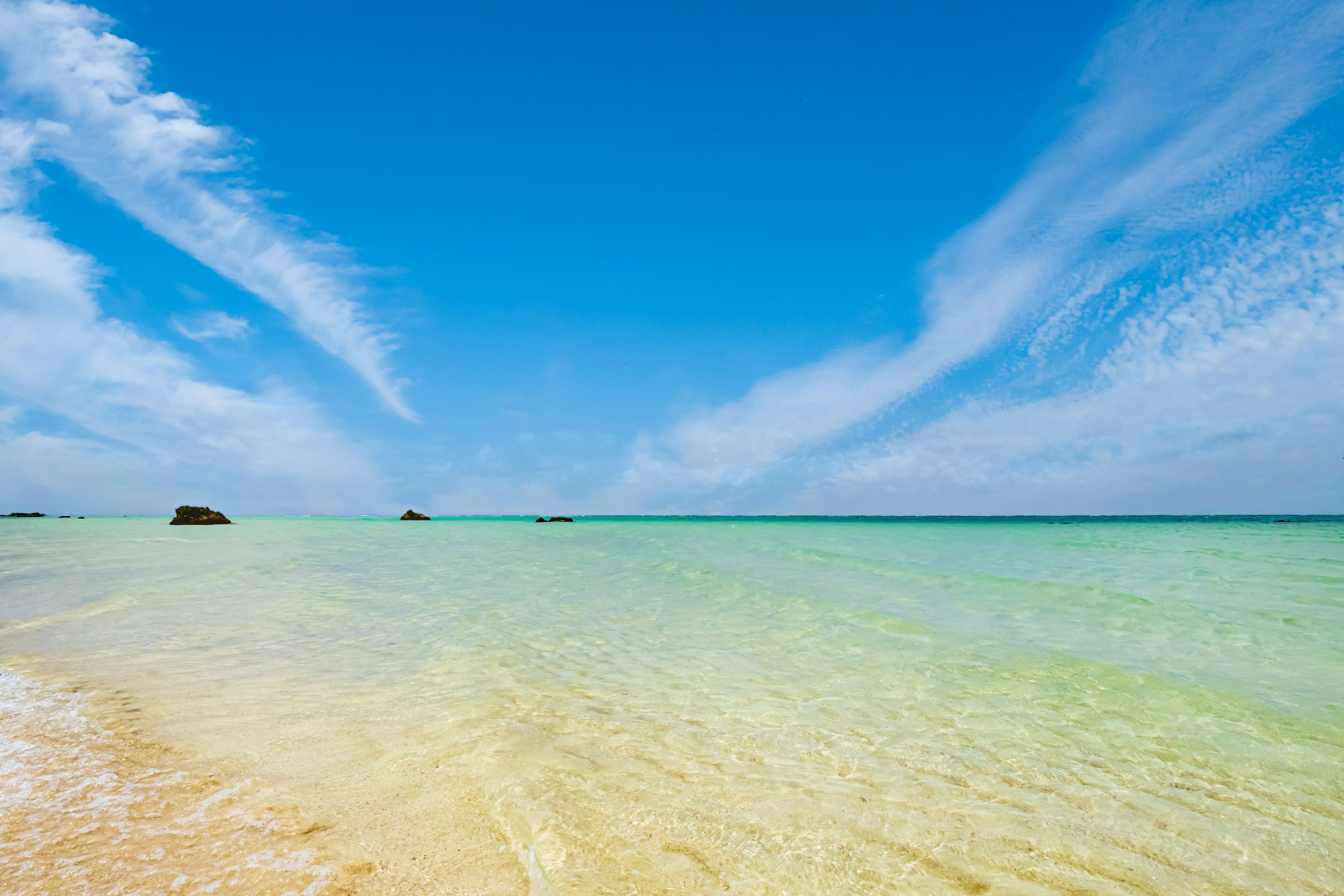 Vue pittoresque du ciel bleu et de l'océan clair avec une plage de sable