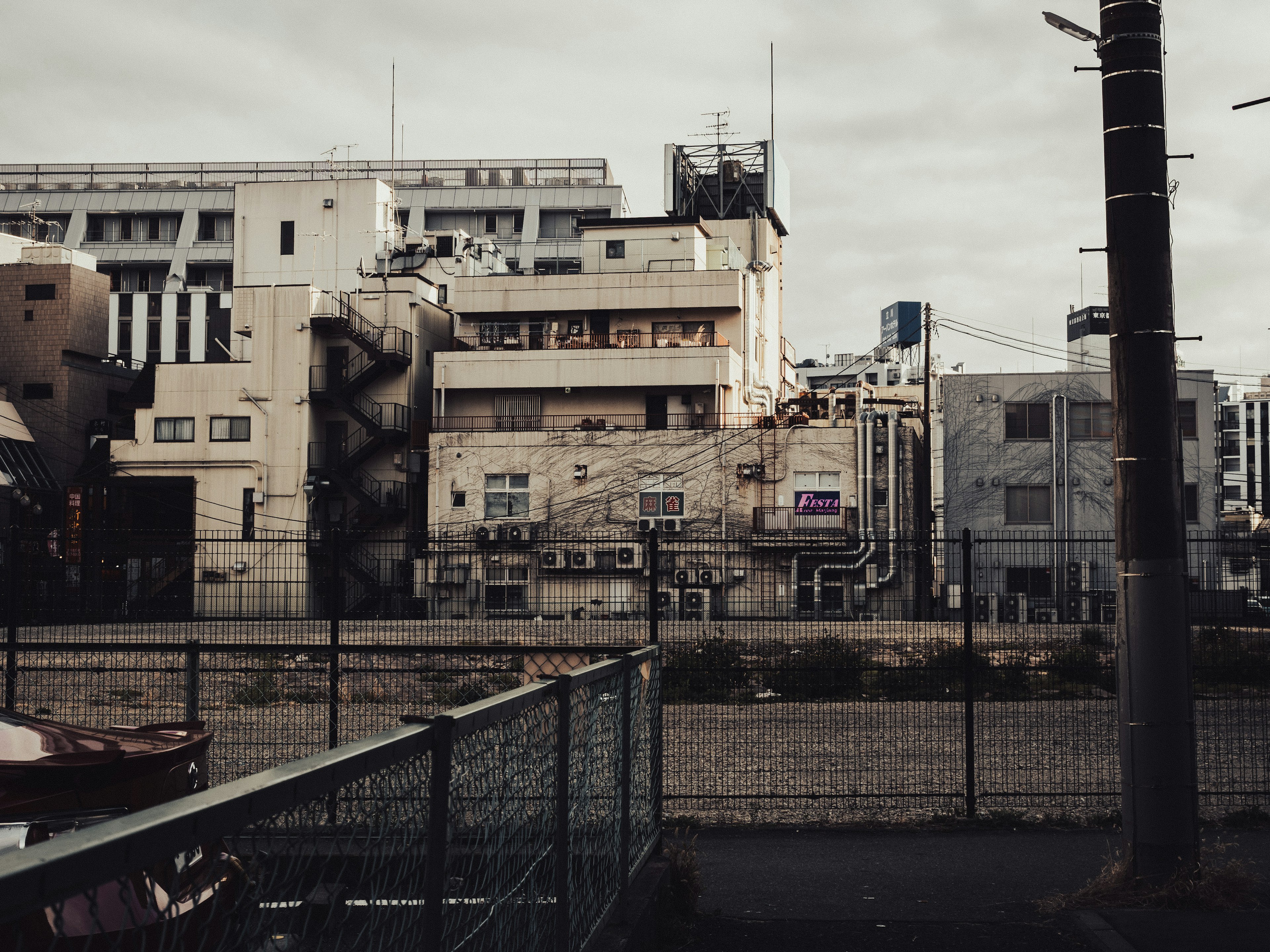 薄暗い都市の風景に古い建物と鉄道の線路が見える