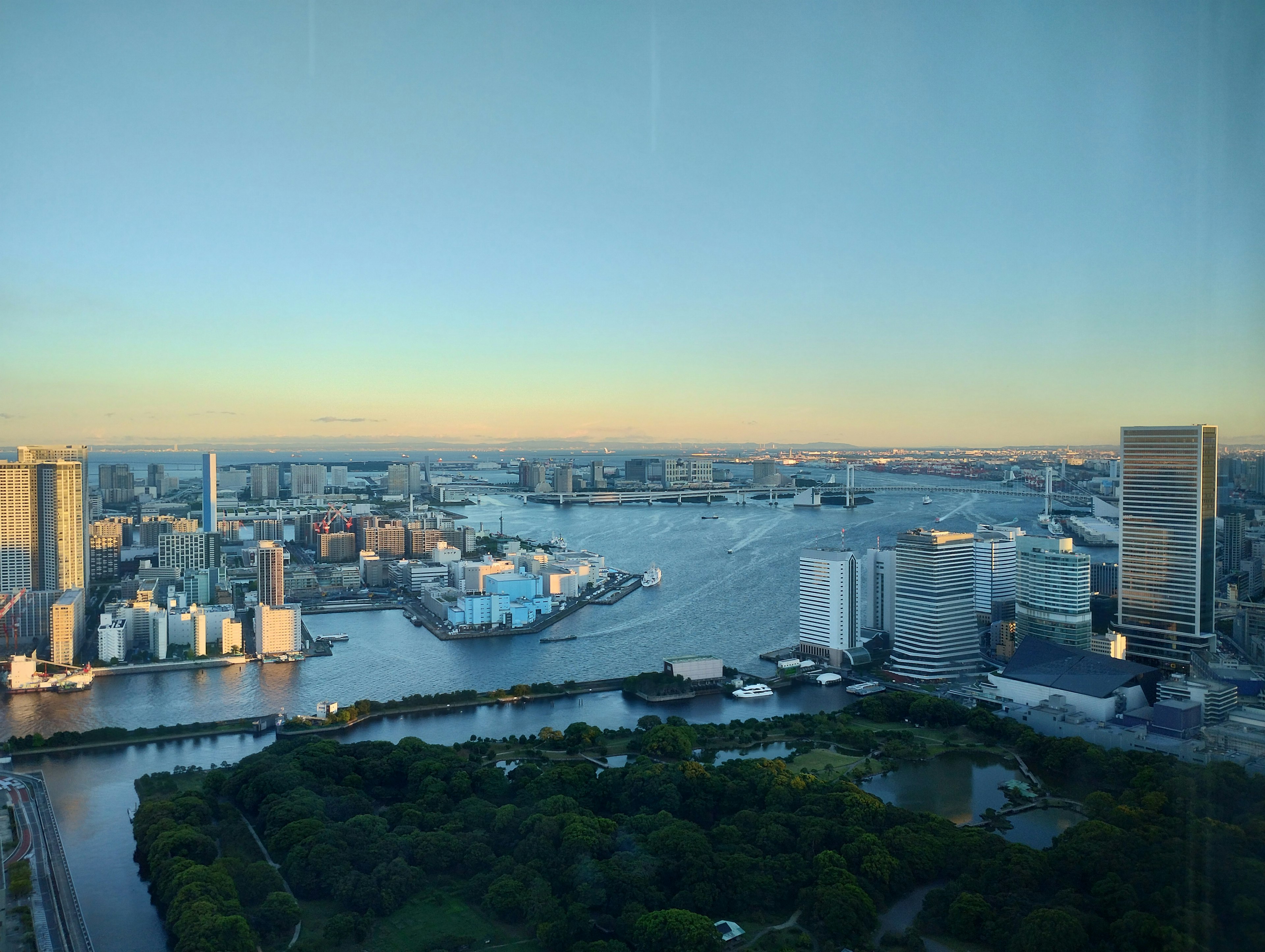 Stadtbild der Bucht von Tokio bei Sonnenuntergang mit grünem Park