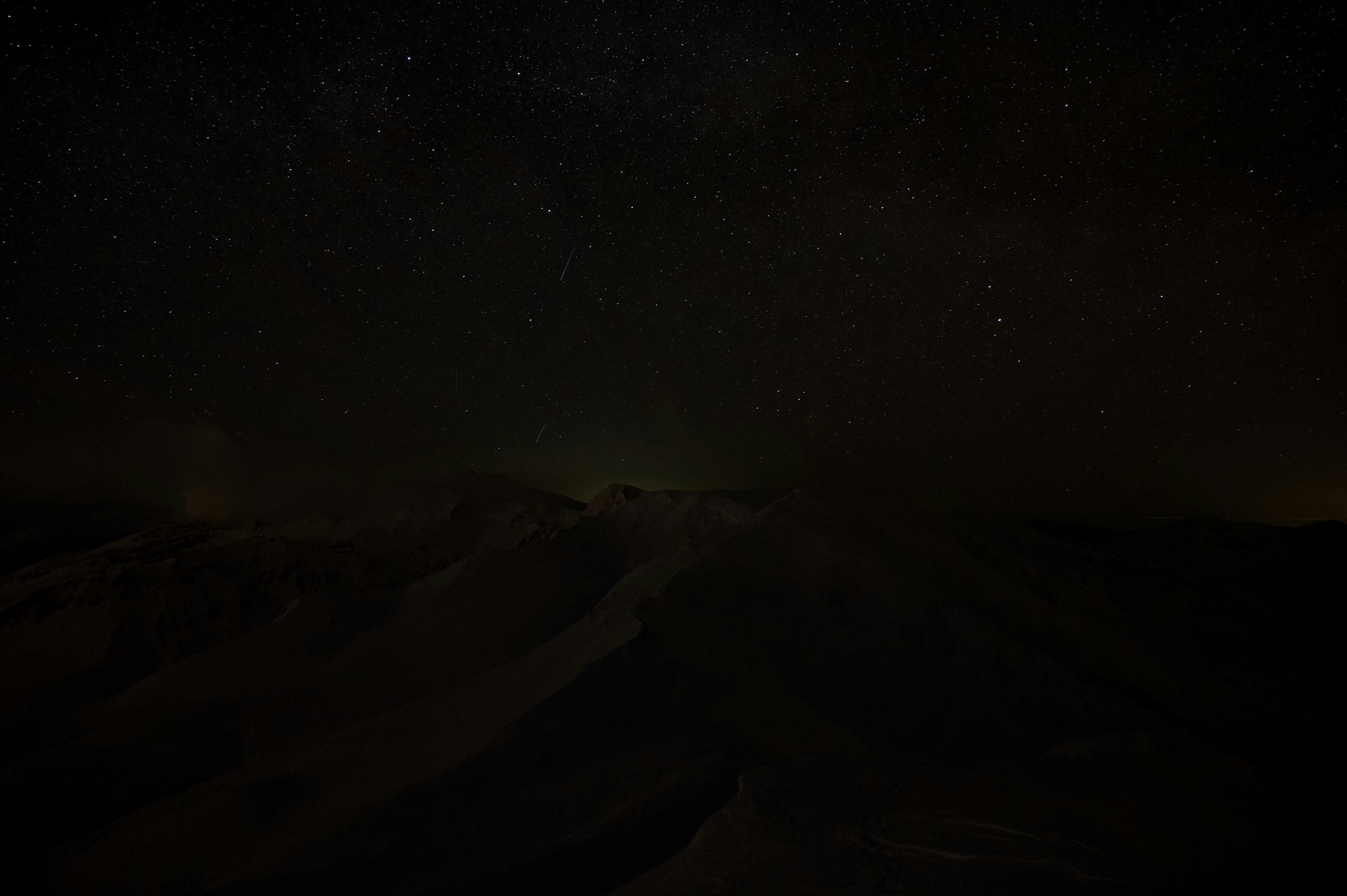 暗い山々の上に広がる星空の風景