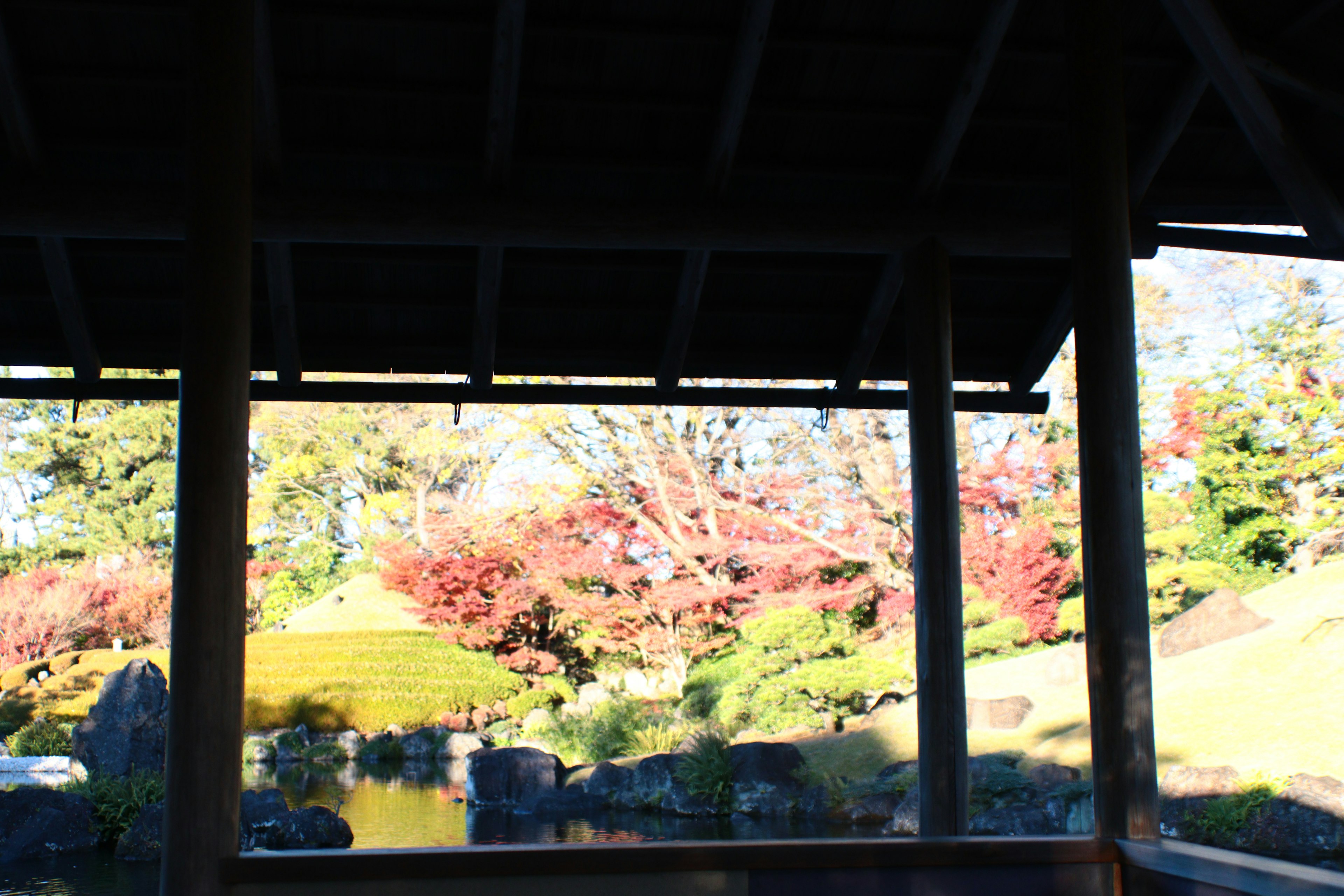 Interior view of a wooden pavilion overlooking a beautiful garden