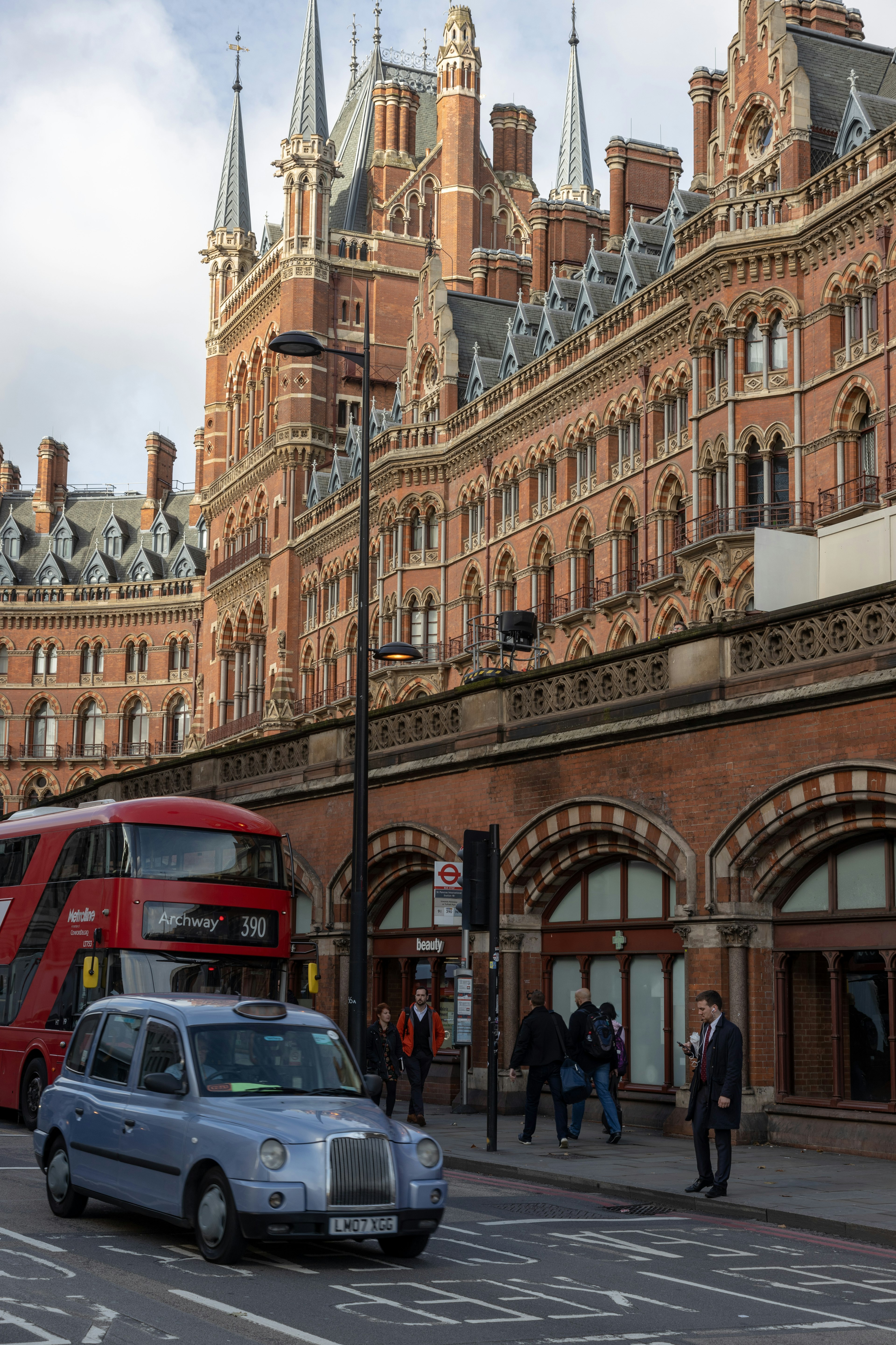 ロンドンのセント・パンクラス駅の歴史的な建物と道路上のタクシー