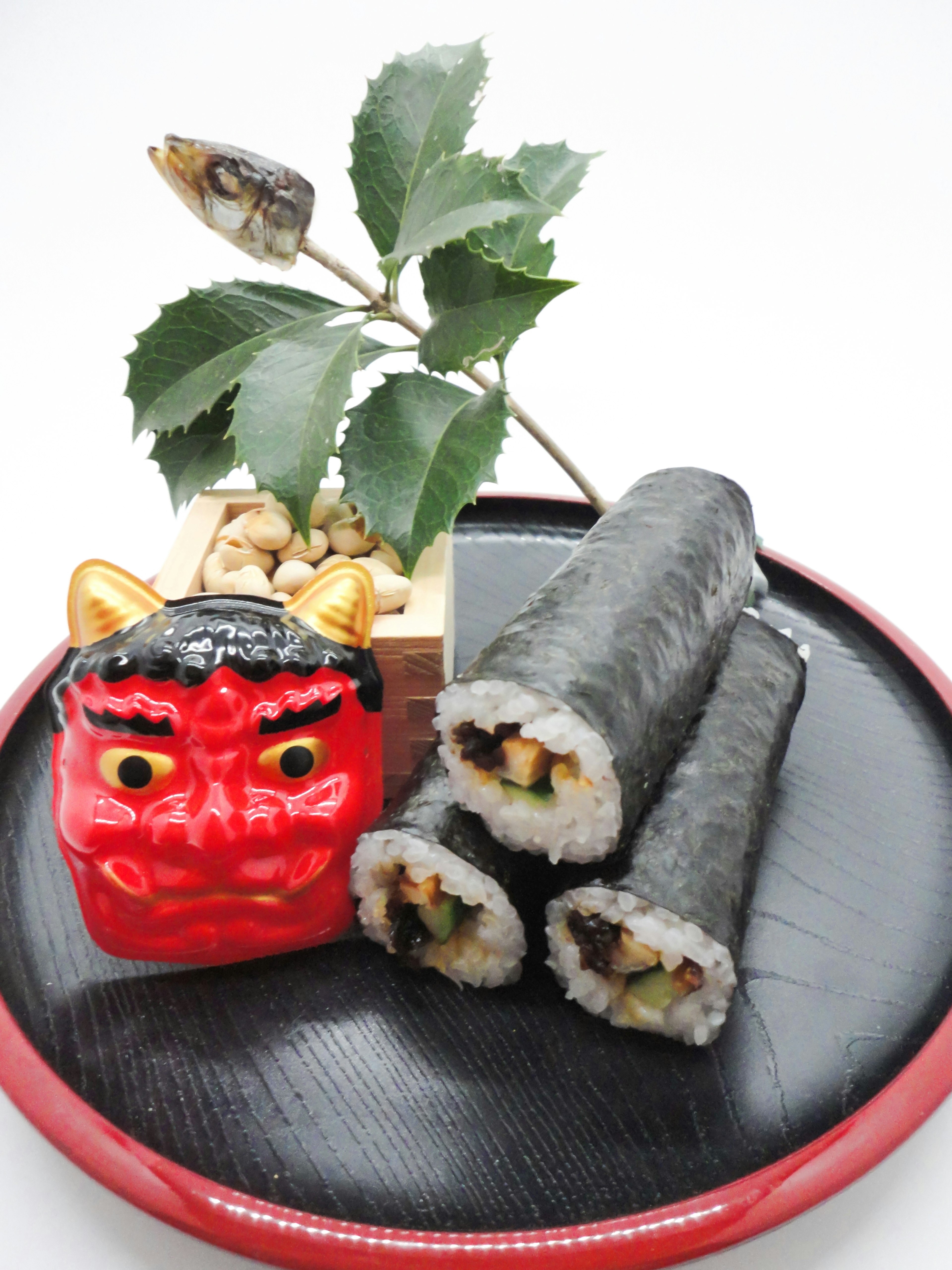 Cara de demonio rojo con rollos de sushi y un arreglo de plantas