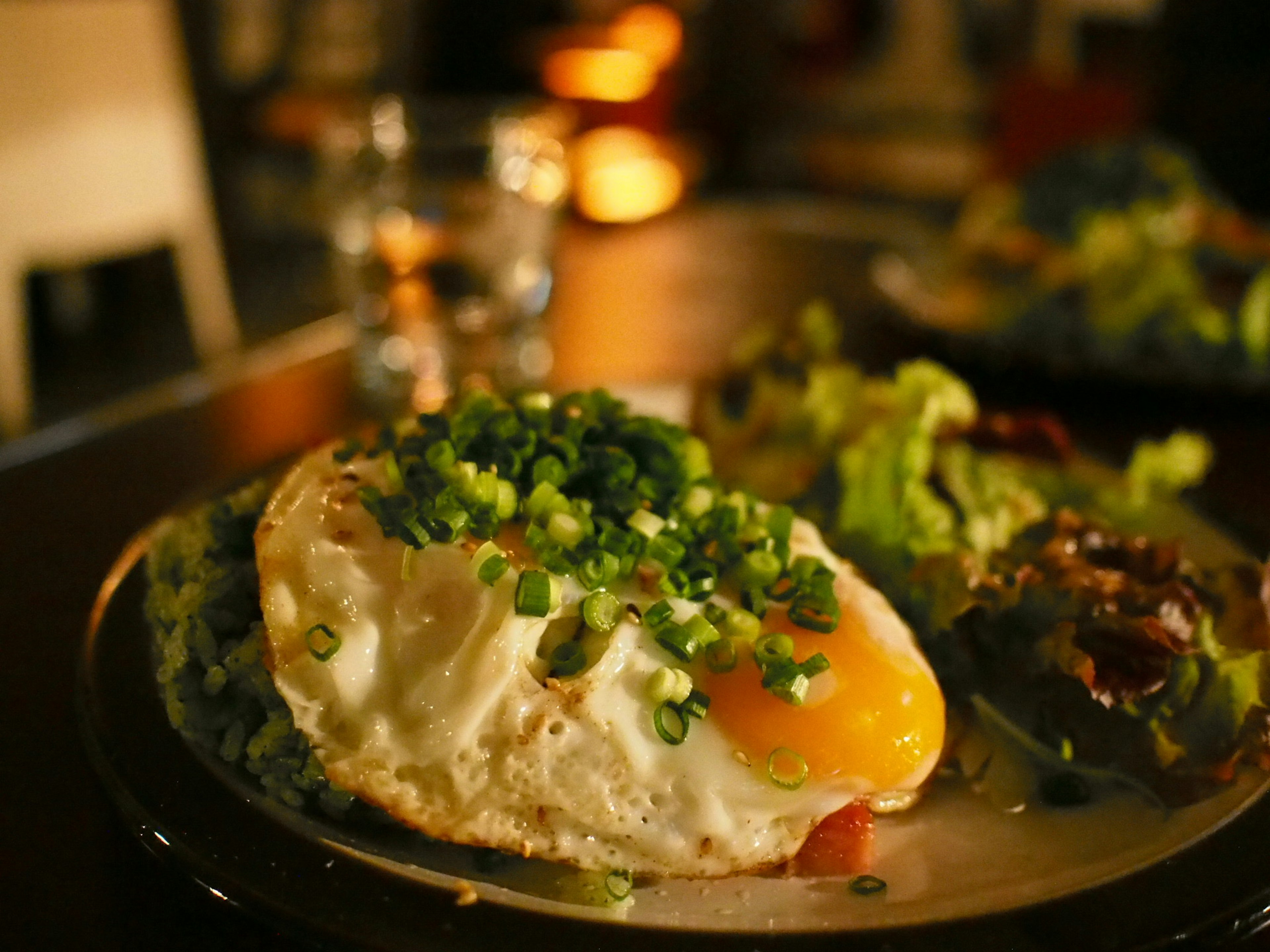 Delicious fried egg topped with green onions served with fresh lettuce