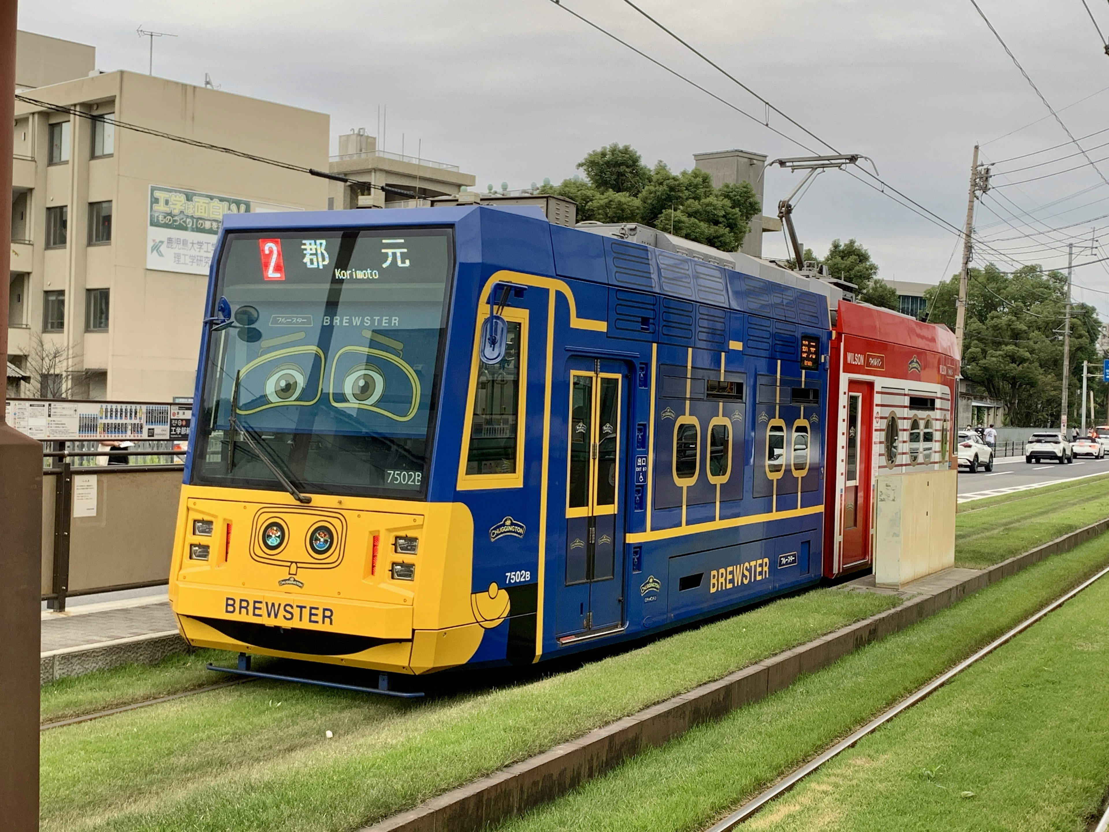 Eine blaue Straßenbahn mit cartoonhaften Designs auf den Gleisen geparkt