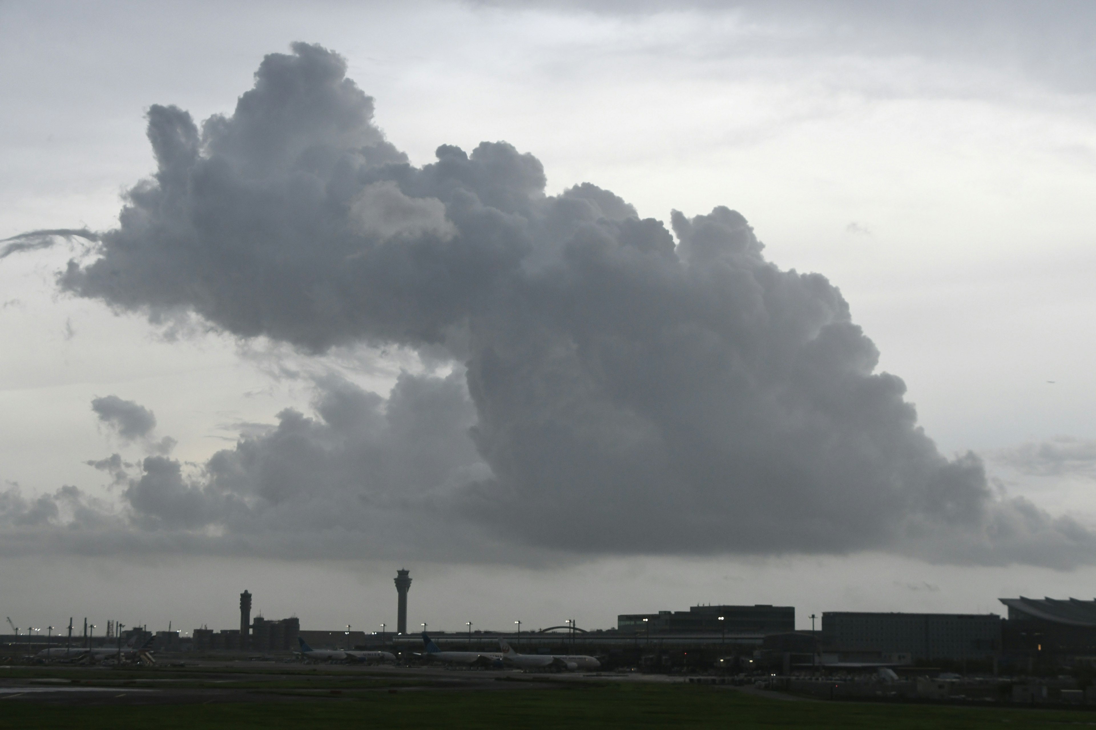 空港の背景に大きな灰色の雲が浮かぶ風景