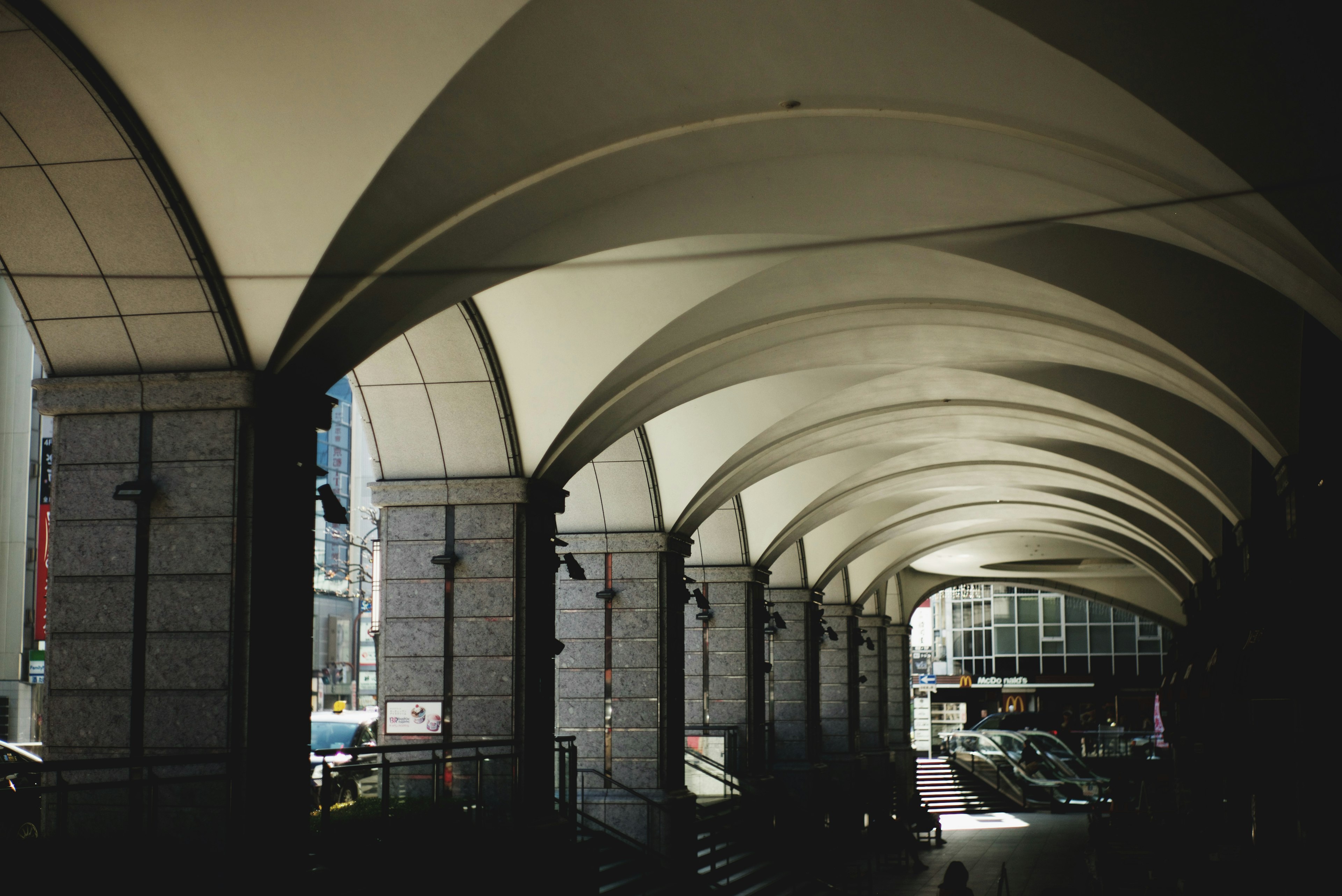 Vista interior de un edificio con estructuras de techo en arco y luz brillante