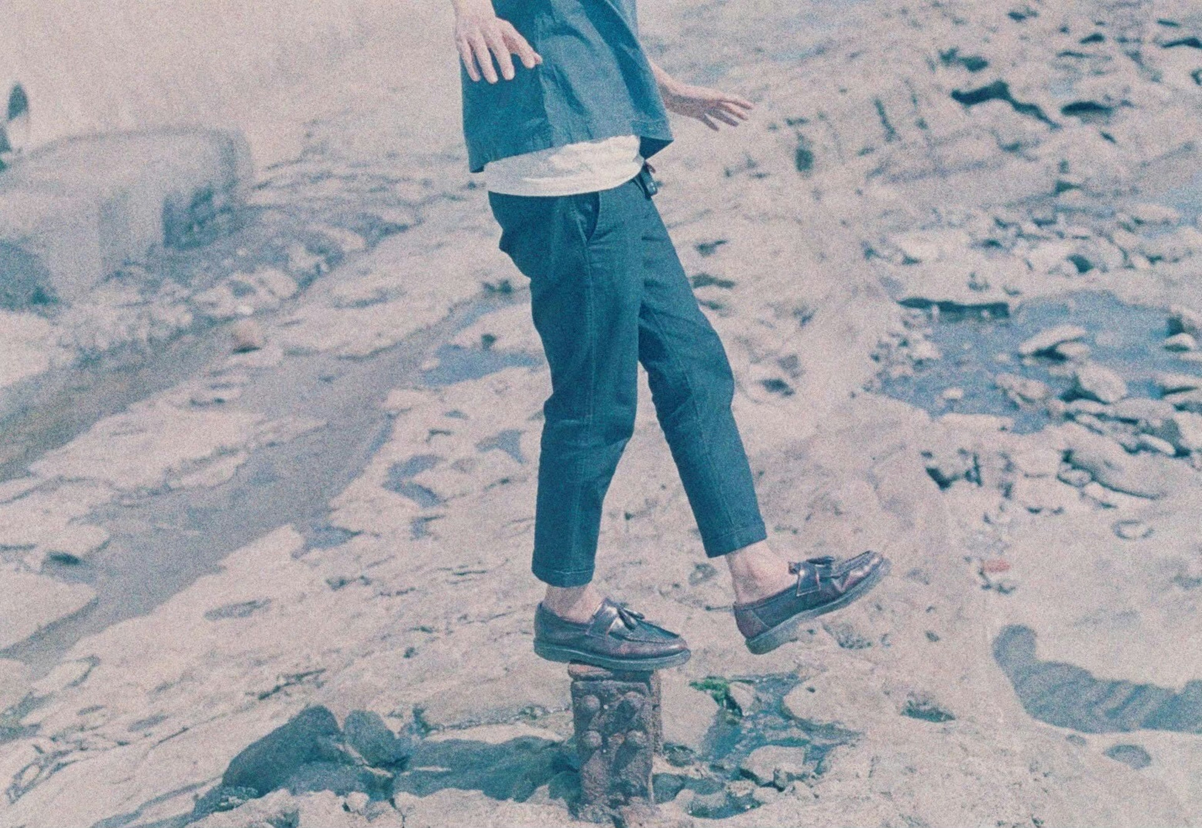 Persona de pie sobre una piedra en un fondo azul