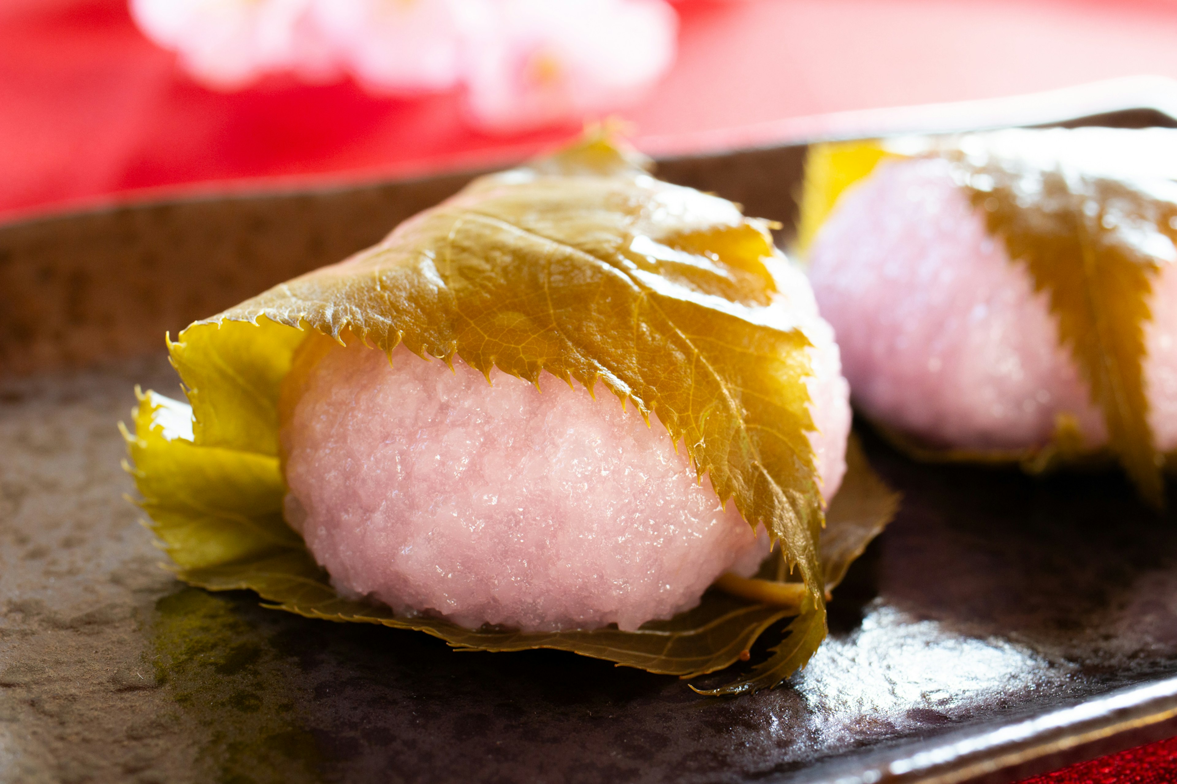 Two cute pink Japanese sweets wrapped in cherry leaves