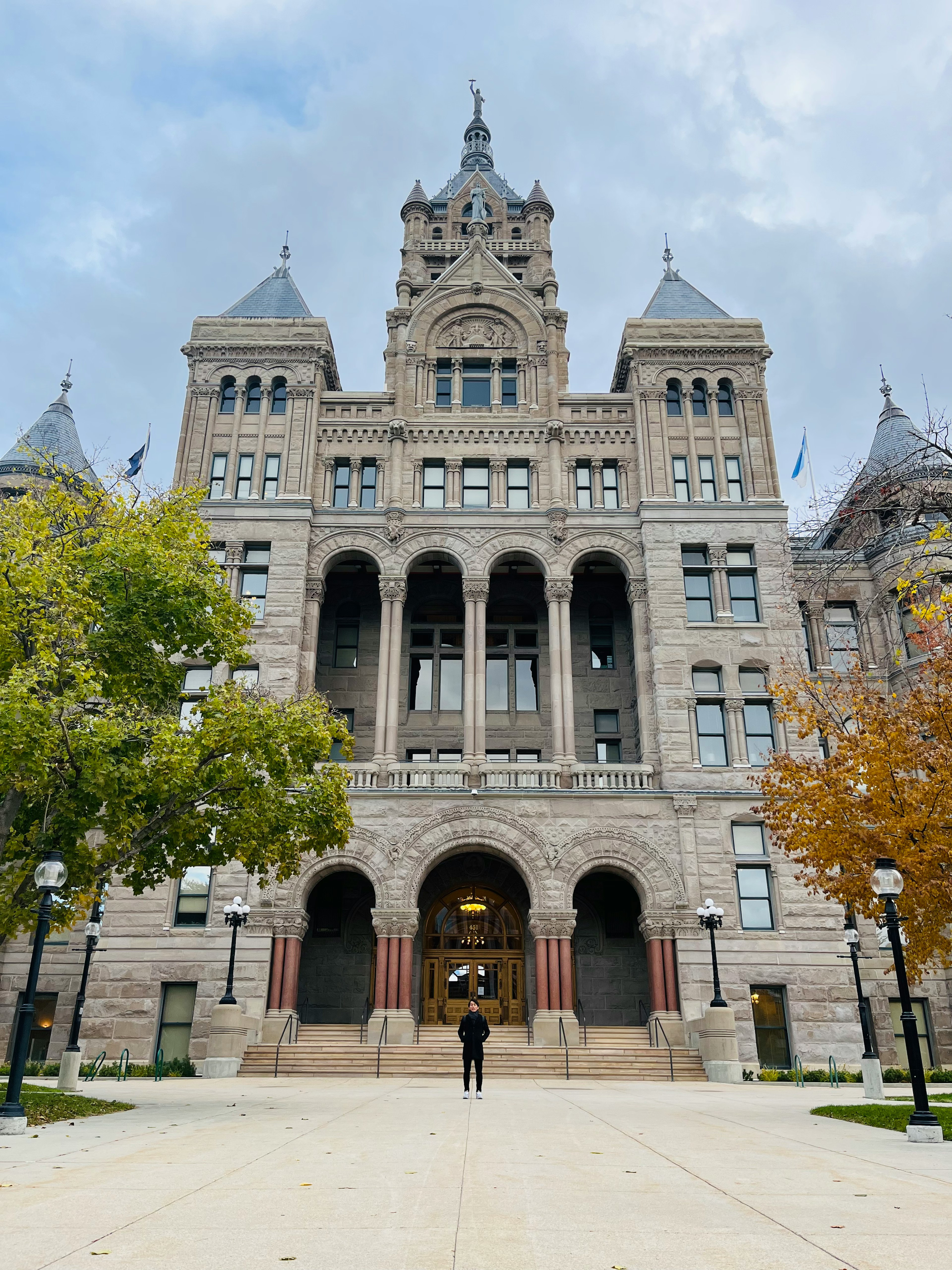 Front view of a beautiful historic building with a stone facade large arched entrance and decorative towers