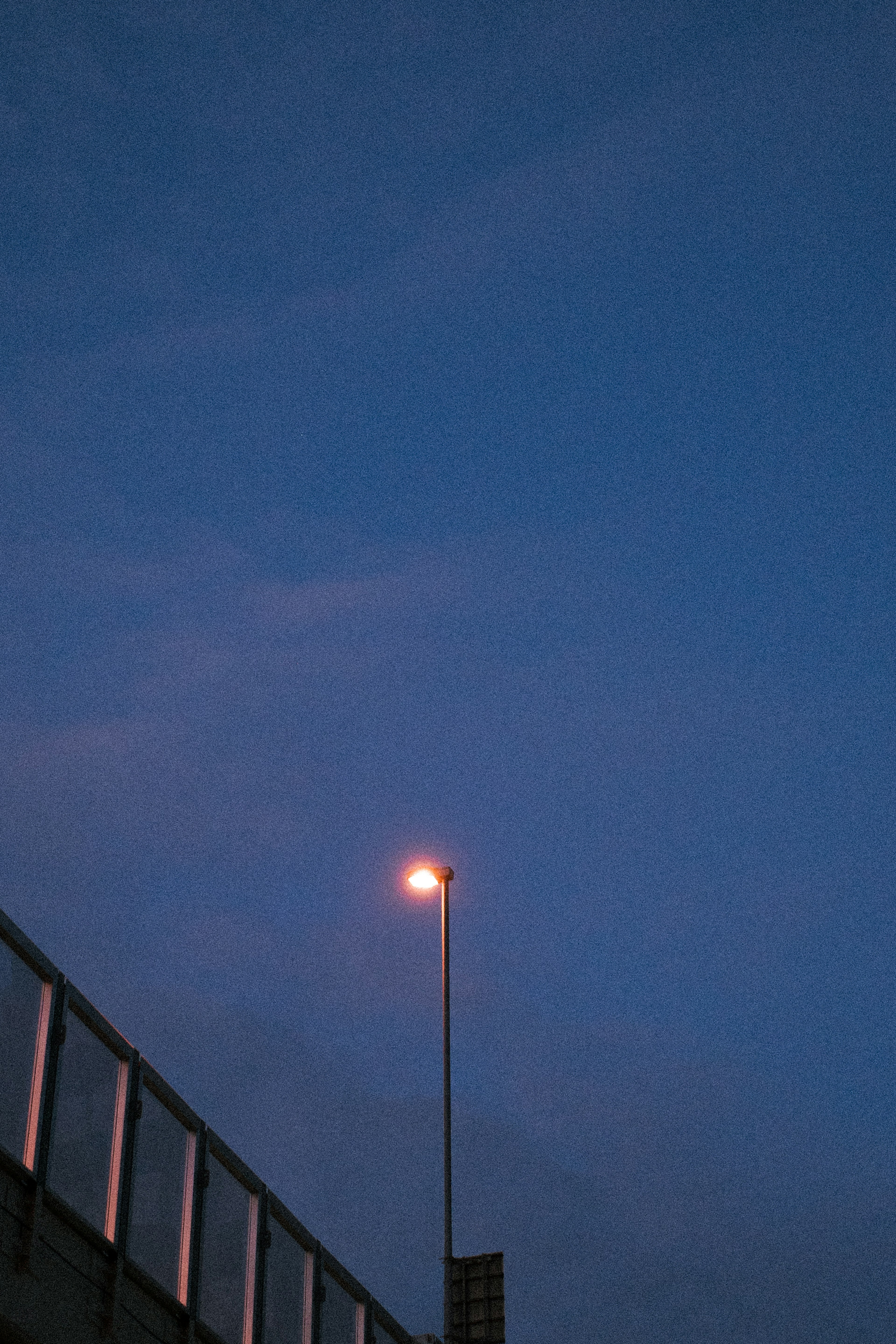 Una farola iluminada contra un cielo oscurecido