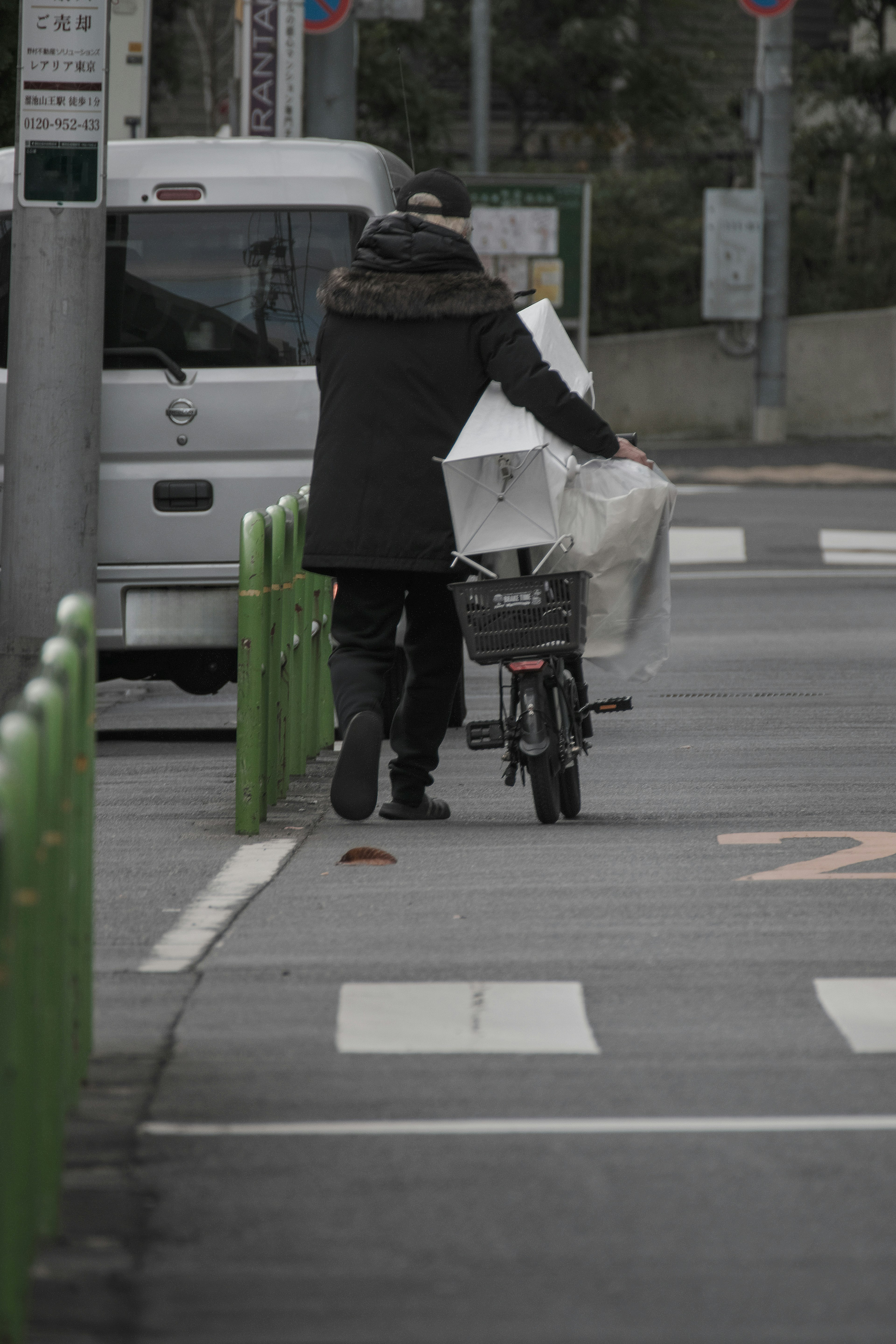 Eine Person, die geht und ein Fahrrad mit Paketen schiebt