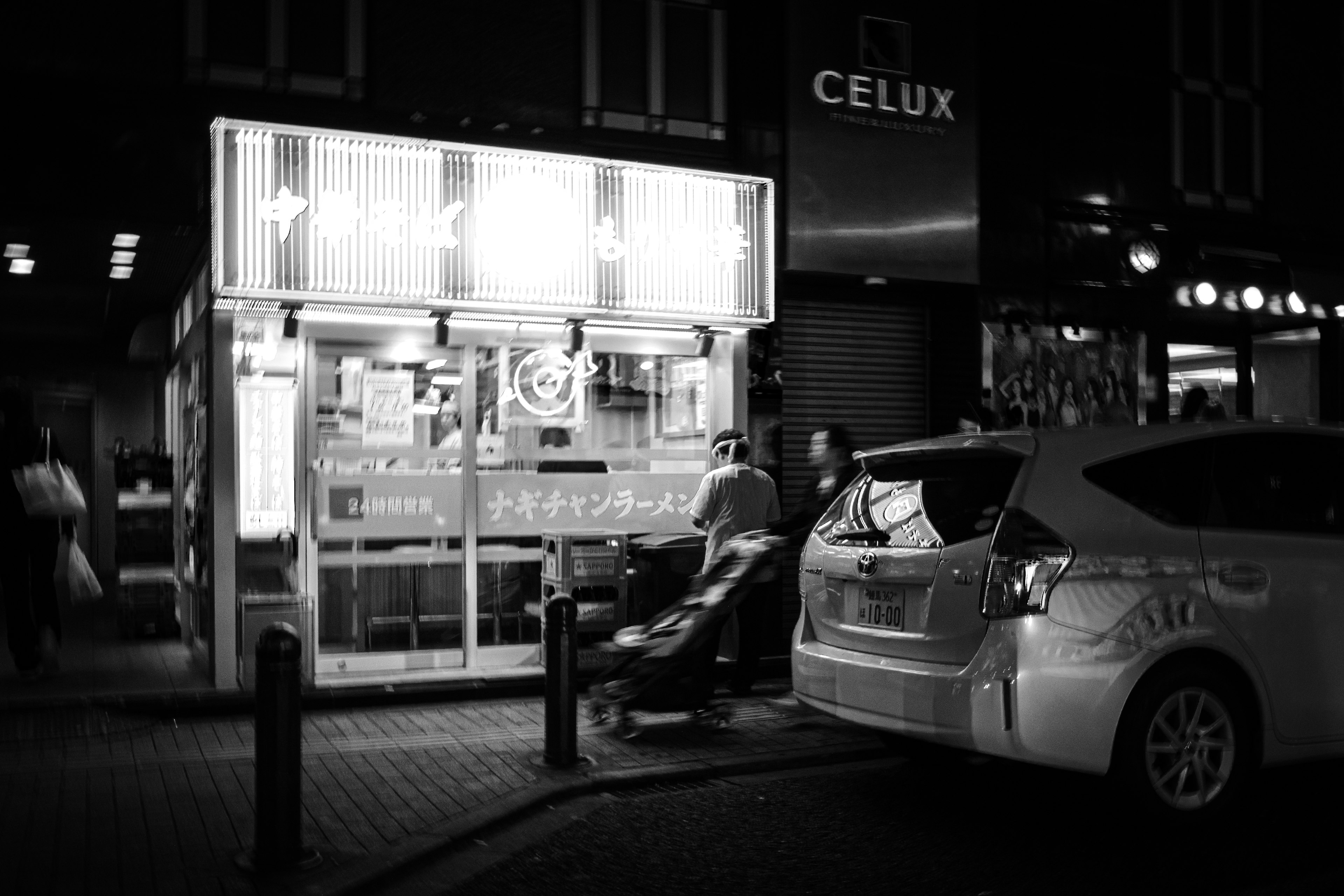 Stand de nourriture de rue nocturne avec une voiture en noir et blanc